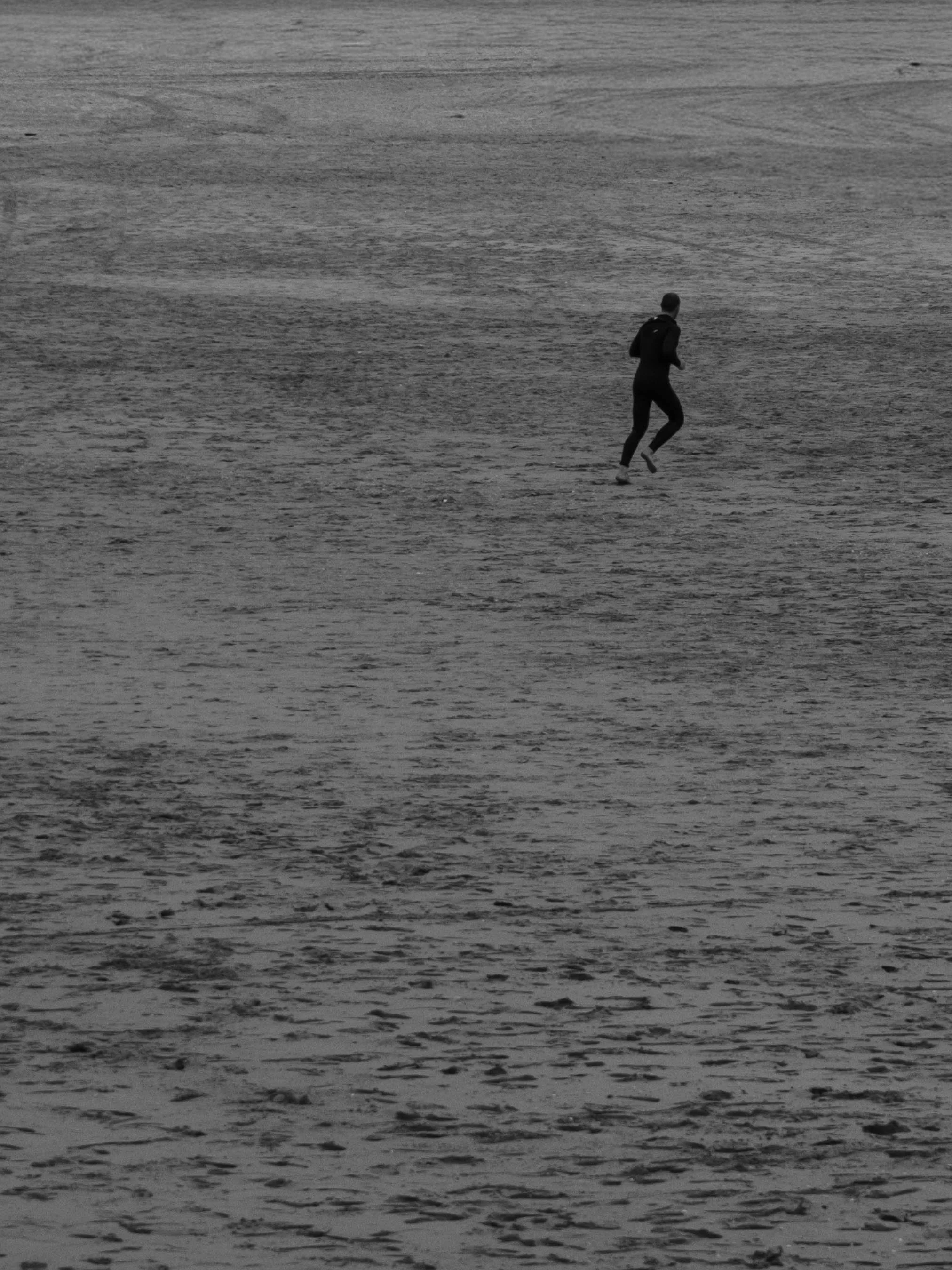 Junge läuft an einem Strand bei Sonnenuntergang entlang.