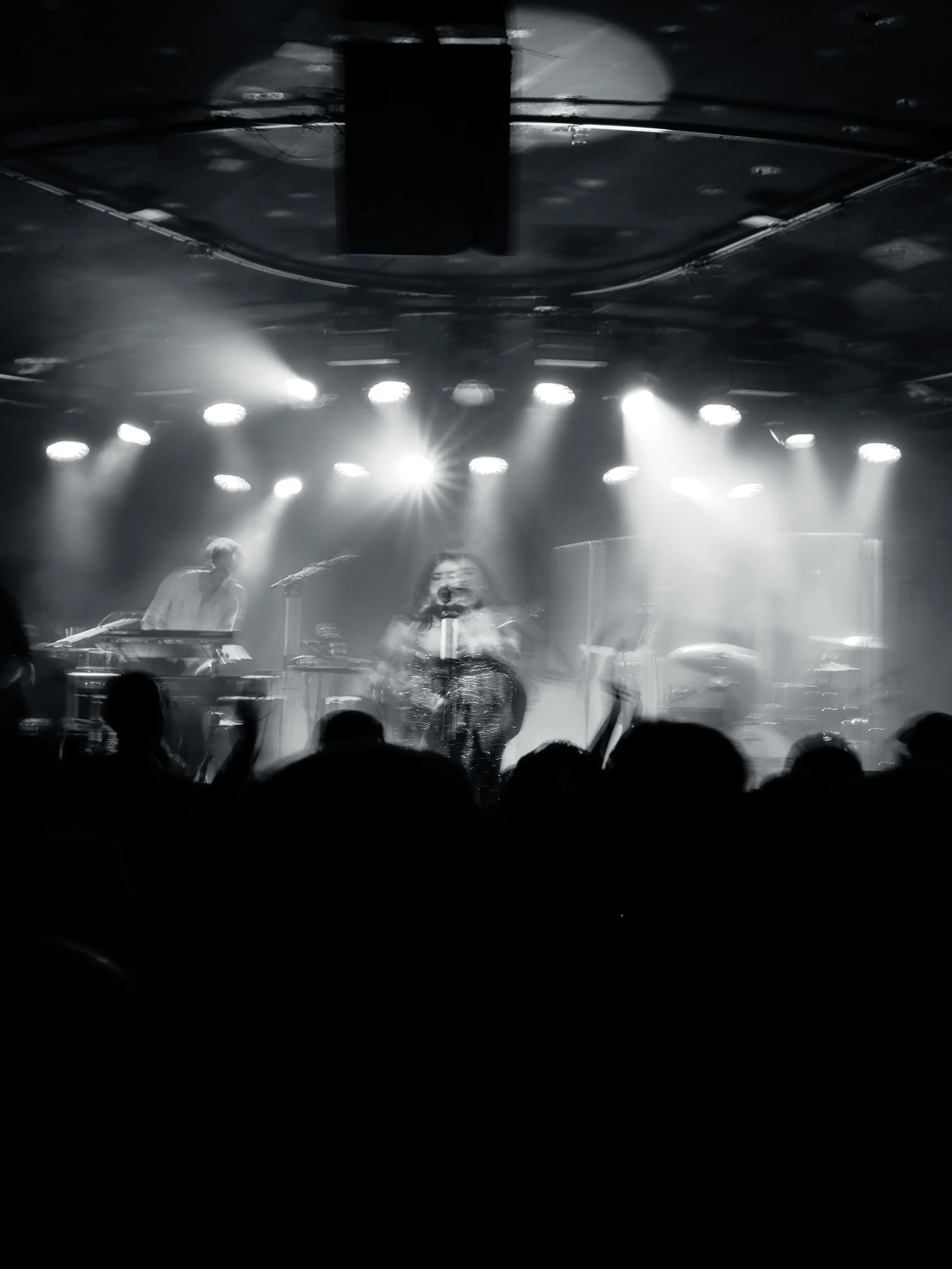 Zwei Musiker auf einer Bühne bei einem Konzert, beleuchtet von mehreren Scheinwerfern, im Schwarzweiß-Stil. Event-Fotografie bei einem Konzert im Zoom, Frankfurt.