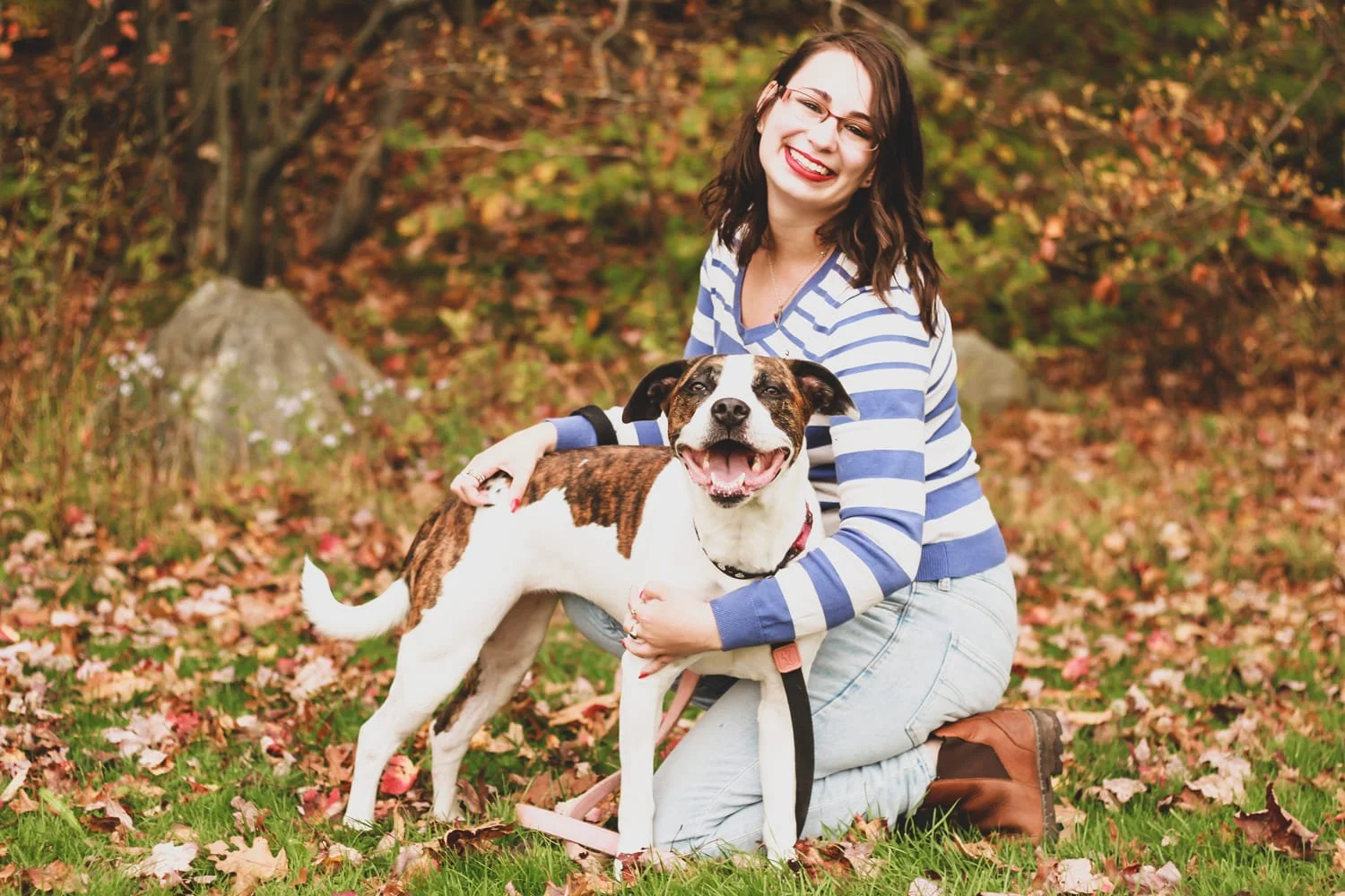 A female couples therapist in Halifax outside with her dog, wearing jeans and a striped sweater