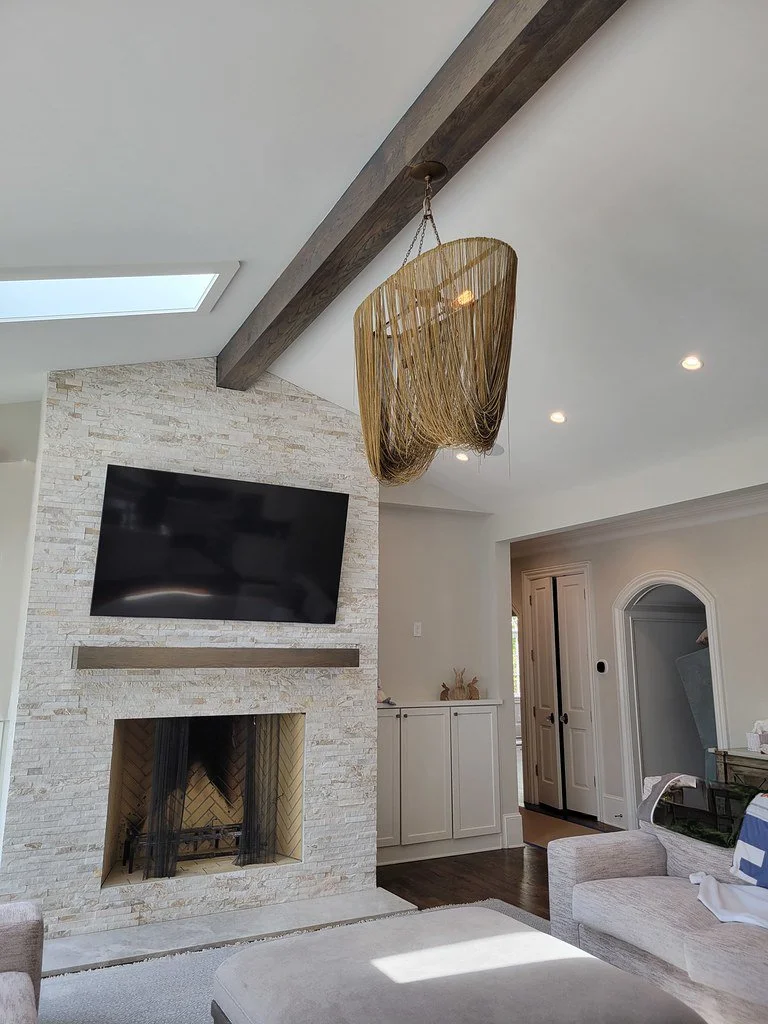 Historic Druid Hills living room with stone fireplace and ceiling beam.