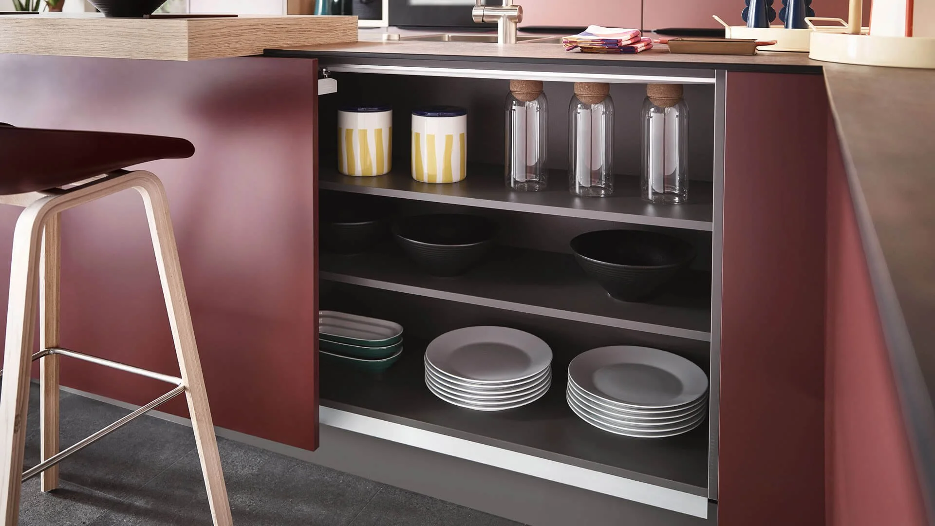 Selma by Sachsenküchen premium luxury bespoke German kitchens. Burgundy red kitchens. Internal kitchen storage. Black cabinet.