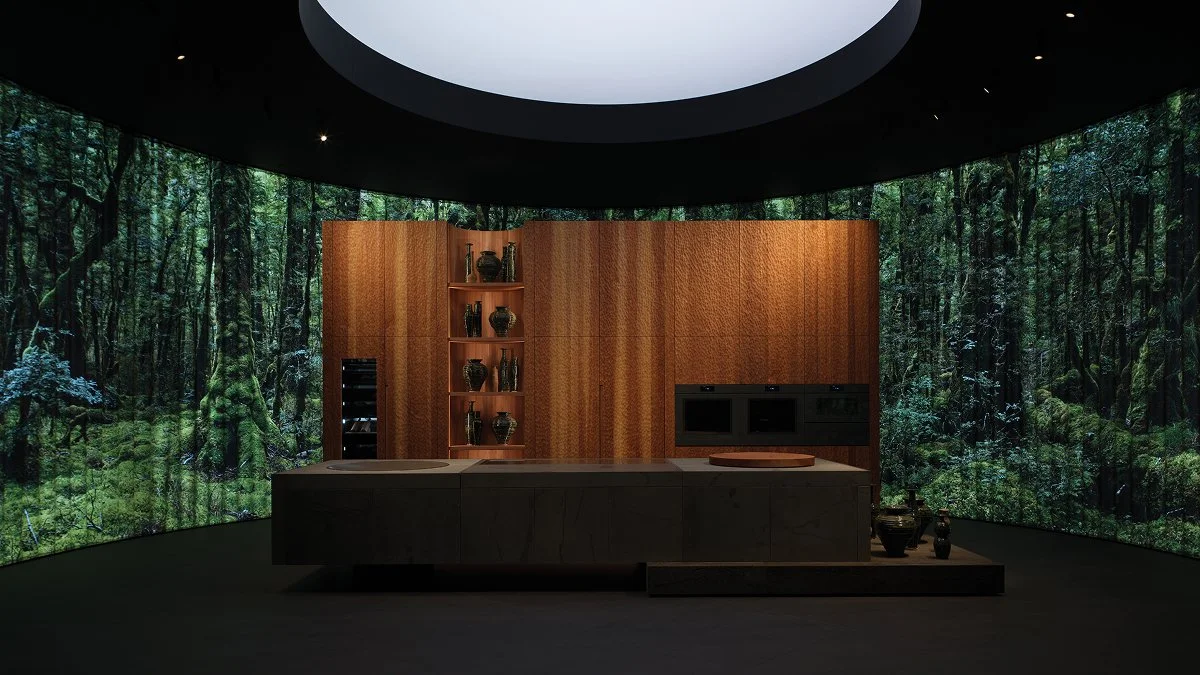 Modern kitchen with a curved forest mural wall backdrop, wooden cabinetry, and built-in appliances. Fisher and Paykel premium appliances. Sachsenküchen bespoke German luxury kitchens.