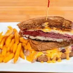 A burger with a beef patty, cheese, and ketchup, served with a side of French fries.
