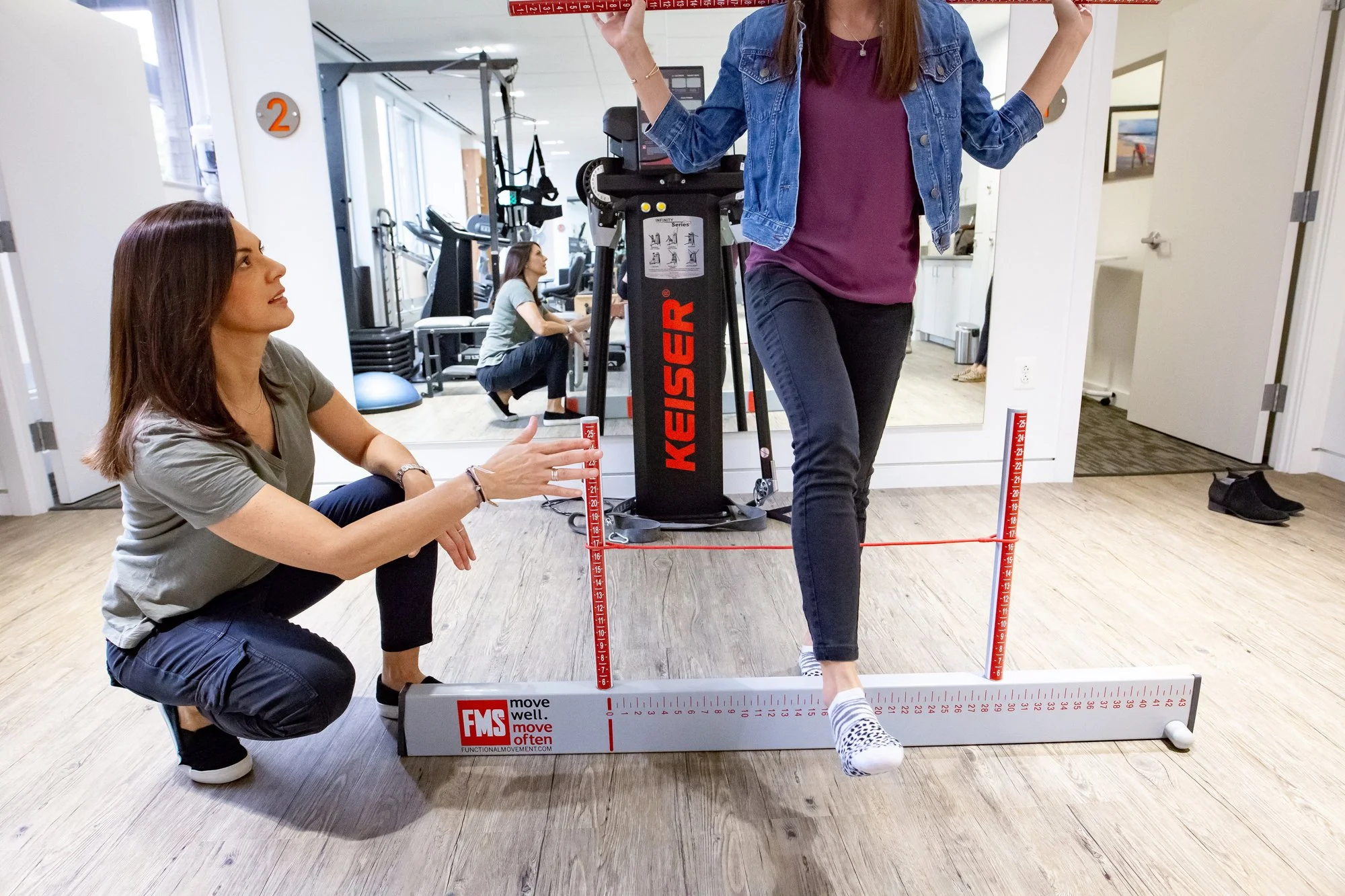 A physical therapist working with a client instead of a personal training session