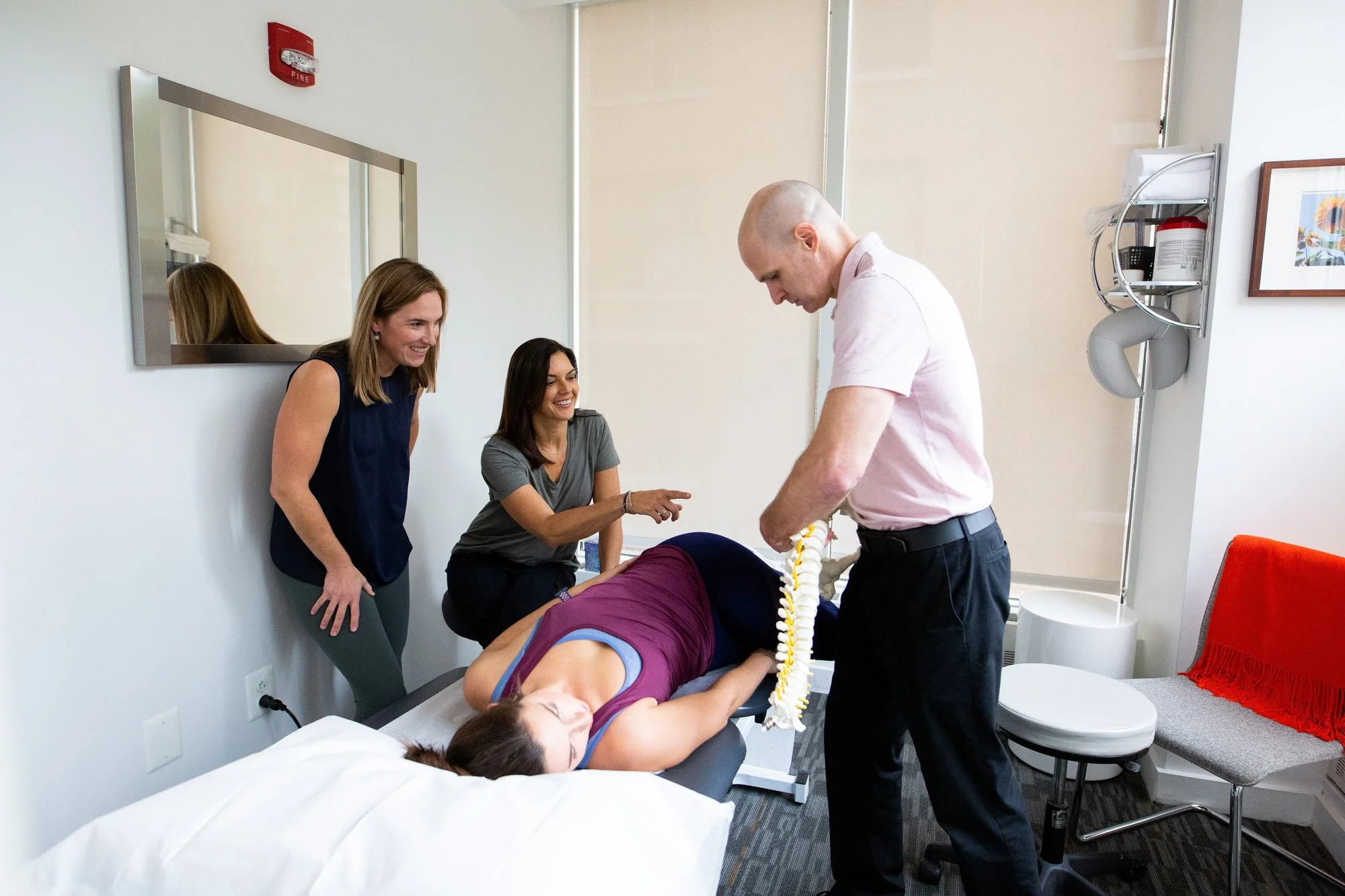 Three physical therapists discussing patient care inside the clinic