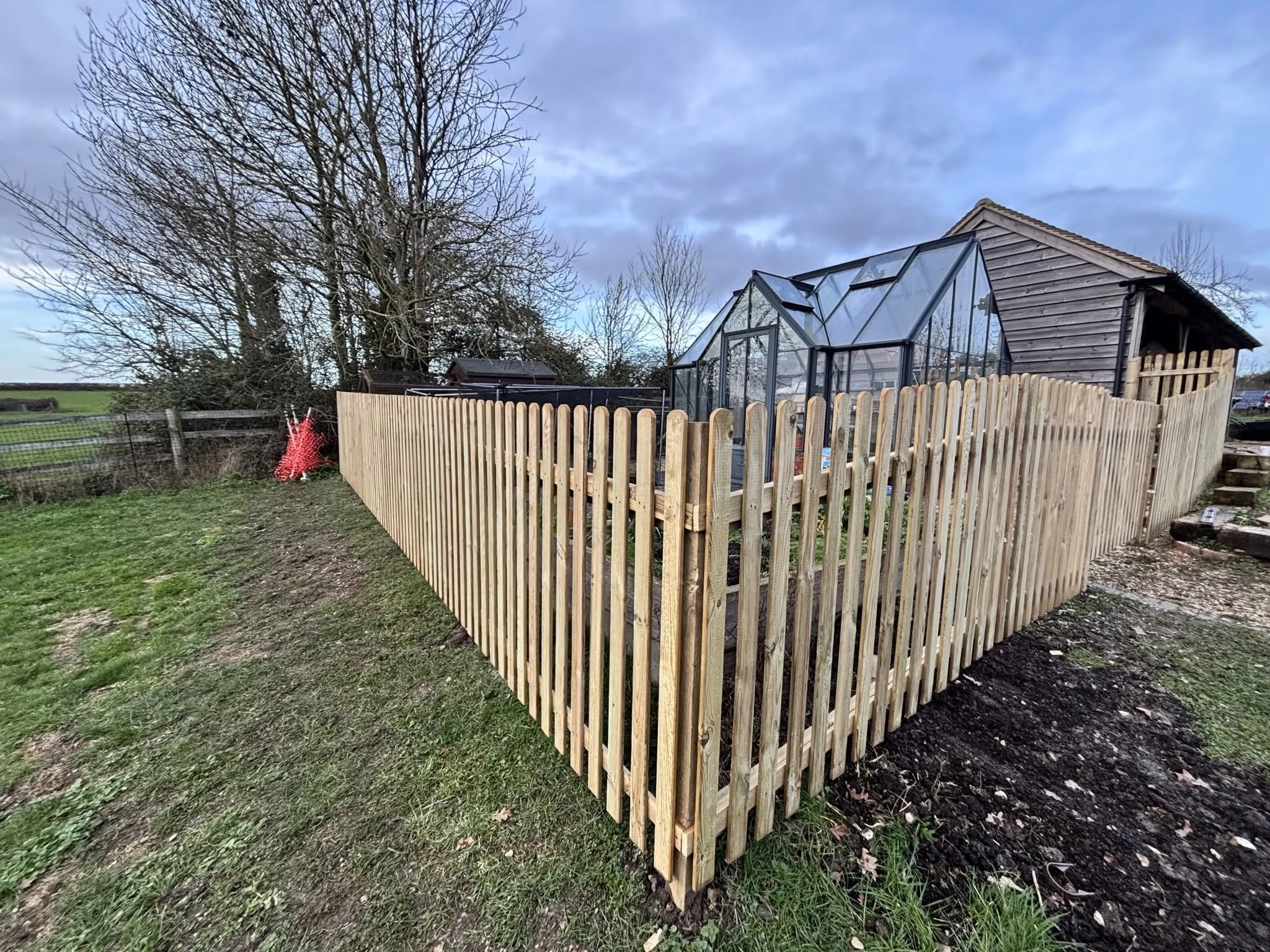 A garden with a wooden picket fence.