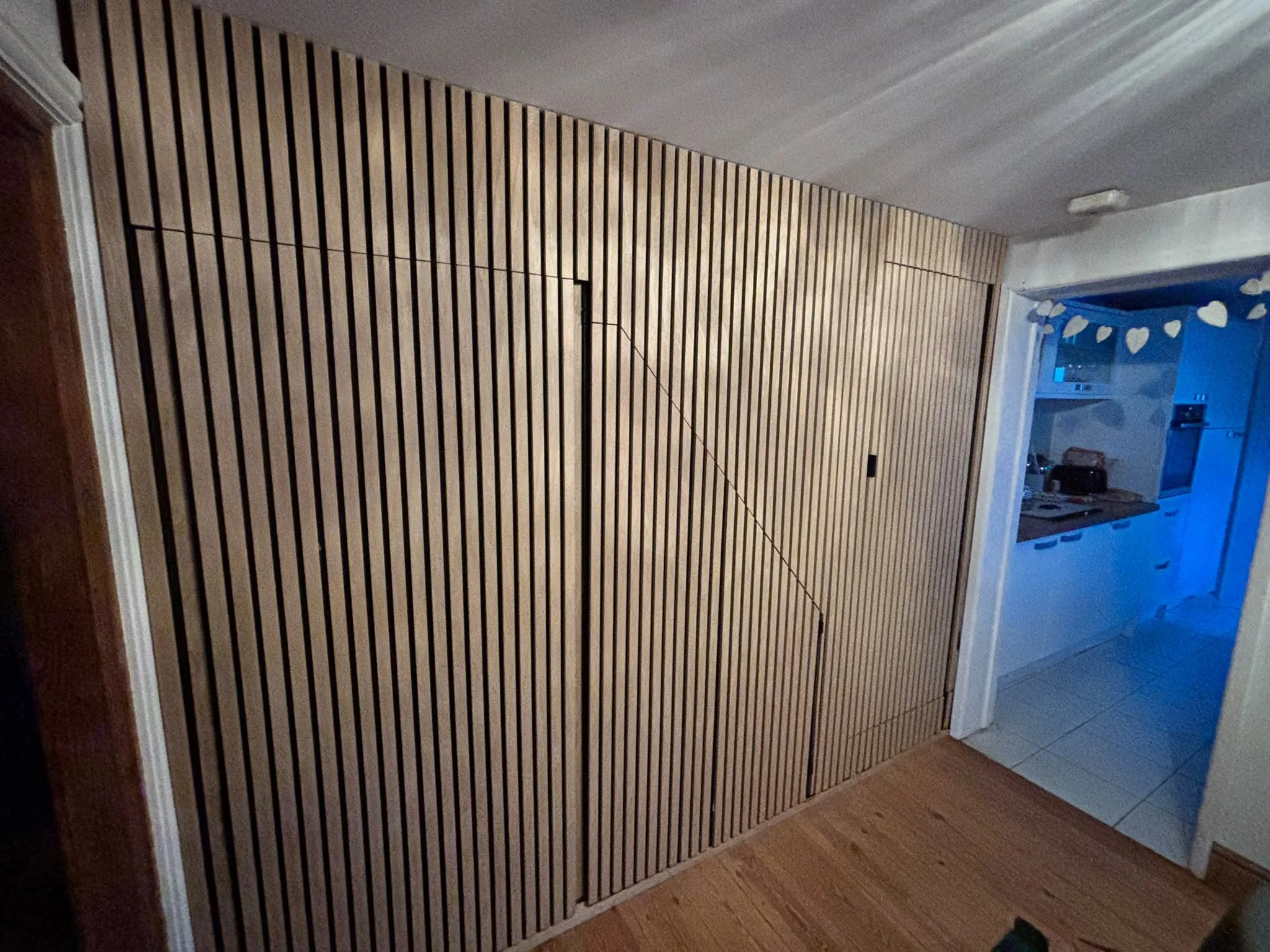A full wall of sound proof wood panelling, with in-built doors.