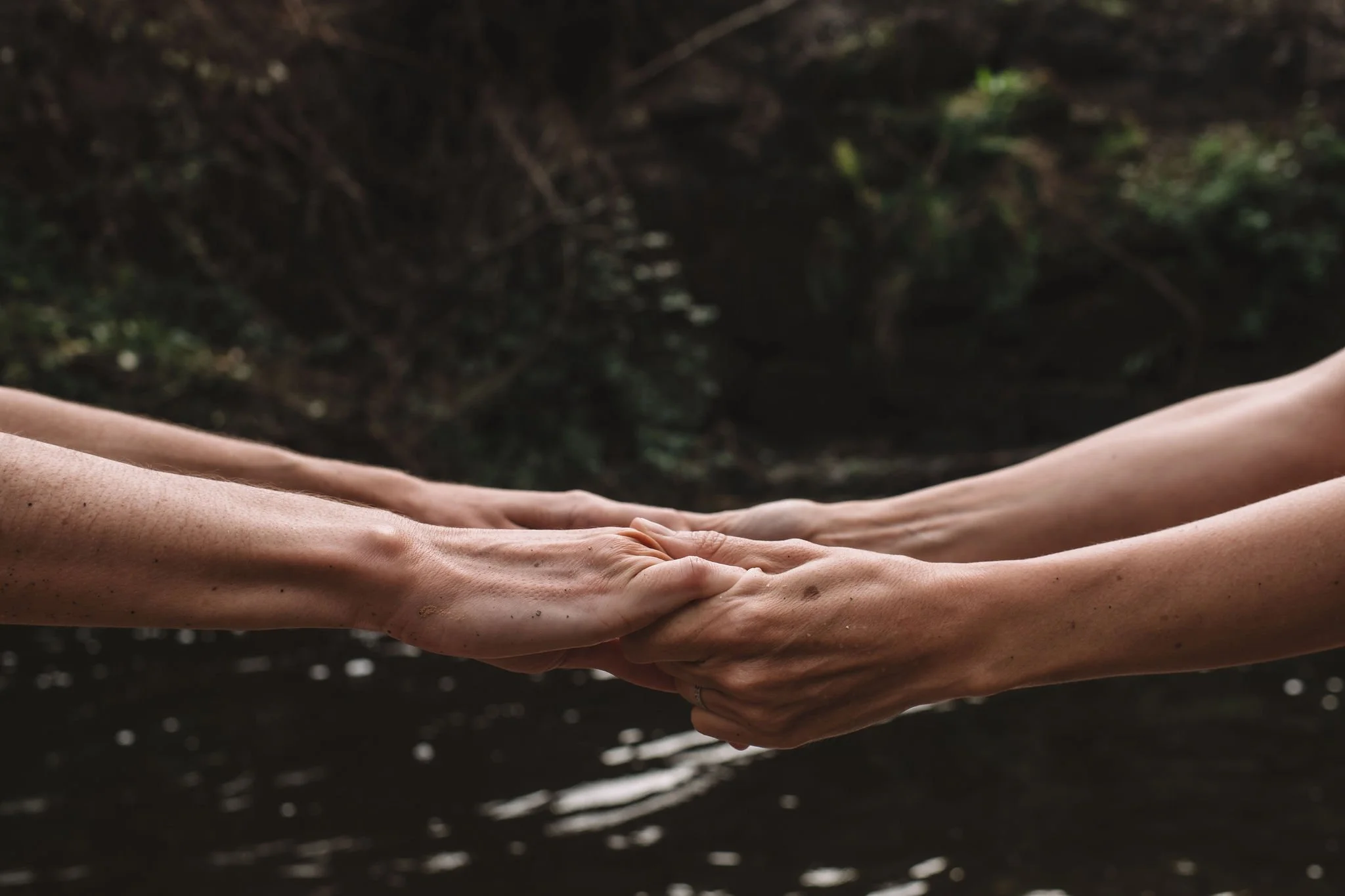 Two women holding hands during a women's retreat.