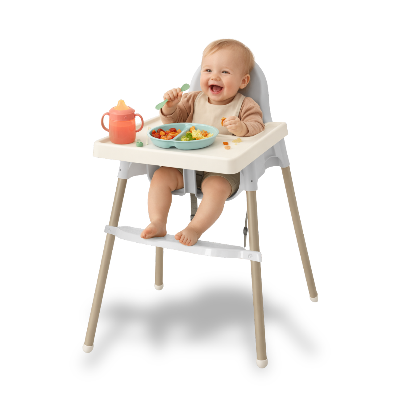 Bebé sonriente sentado en una silla para comer elevada, con plato de comida infantil y una taza con tapa anaranjada, comiendo con una cuchara verde.