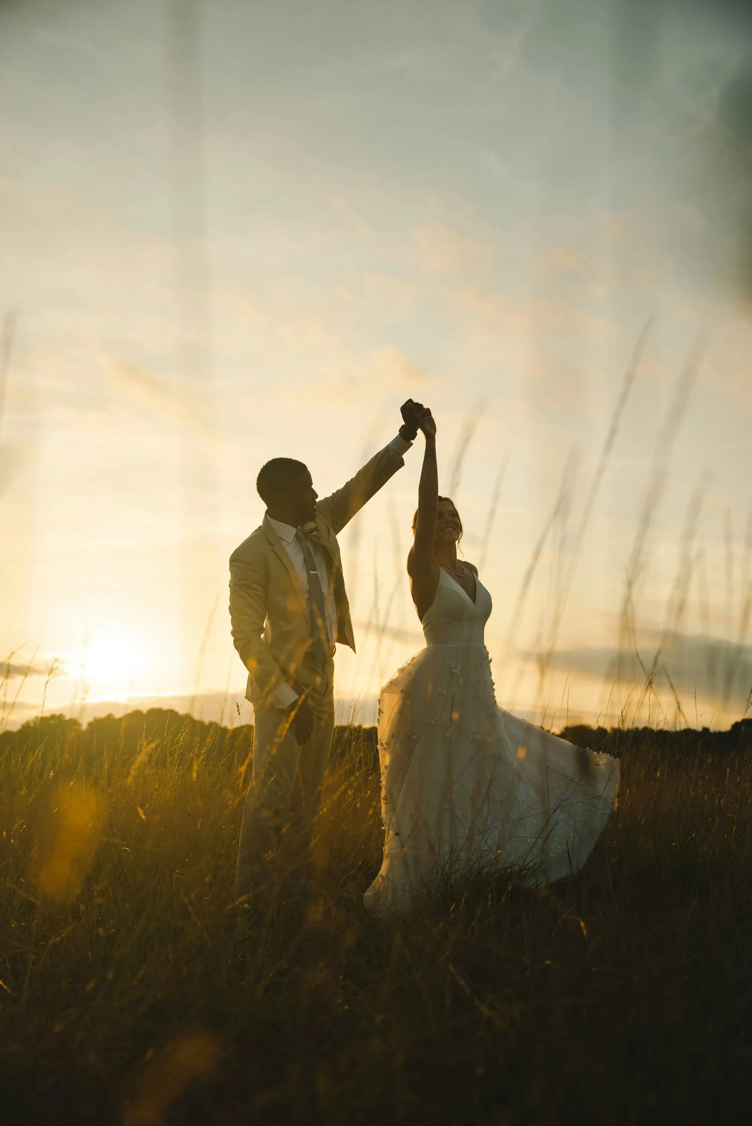 Emotionale Aufnahme eines Brautpaares bei Sonnenuntergang als Inspiration für individuelle Hochzeitsplanung und Destination Weddings.
