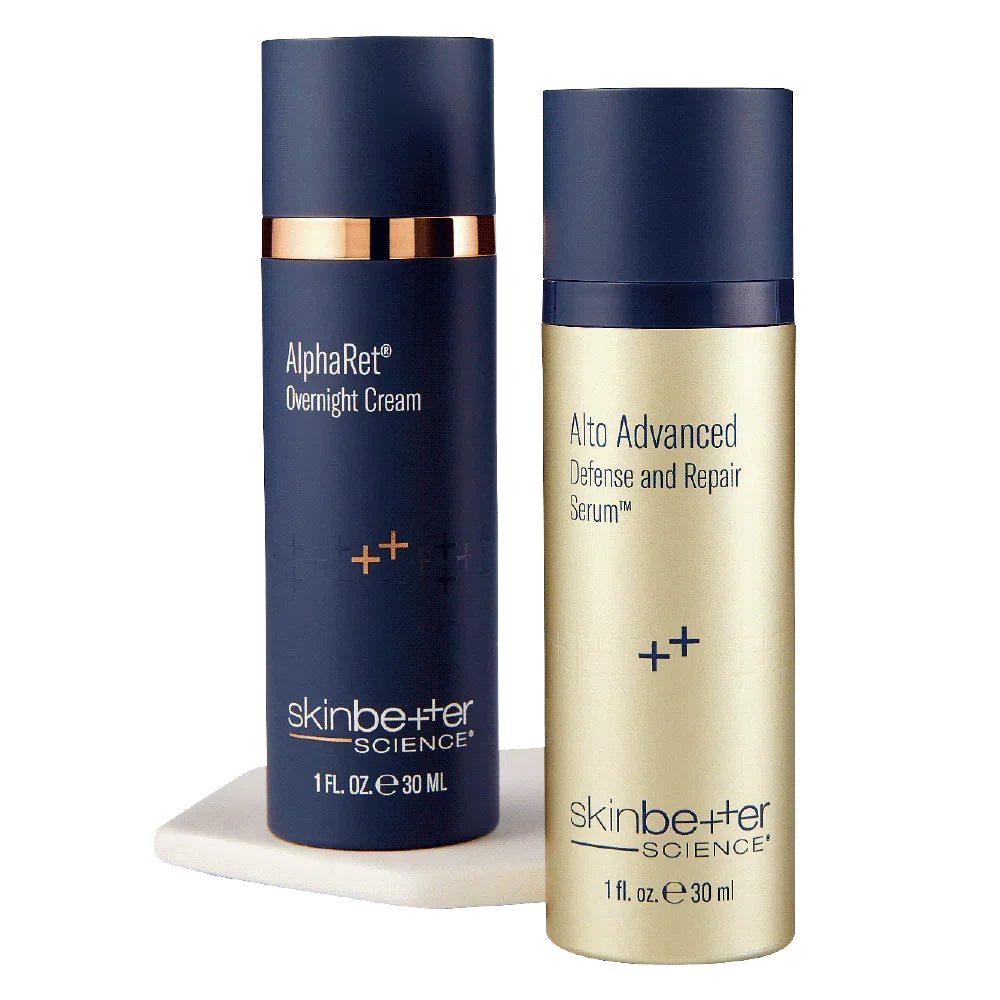 Two skincare bottles, one labeled AlphaRet Overnight Cream with a dark blue container and rose gold band, and the other labeled Alto Advanced Defense and Repair Serum with a pale gold container.
