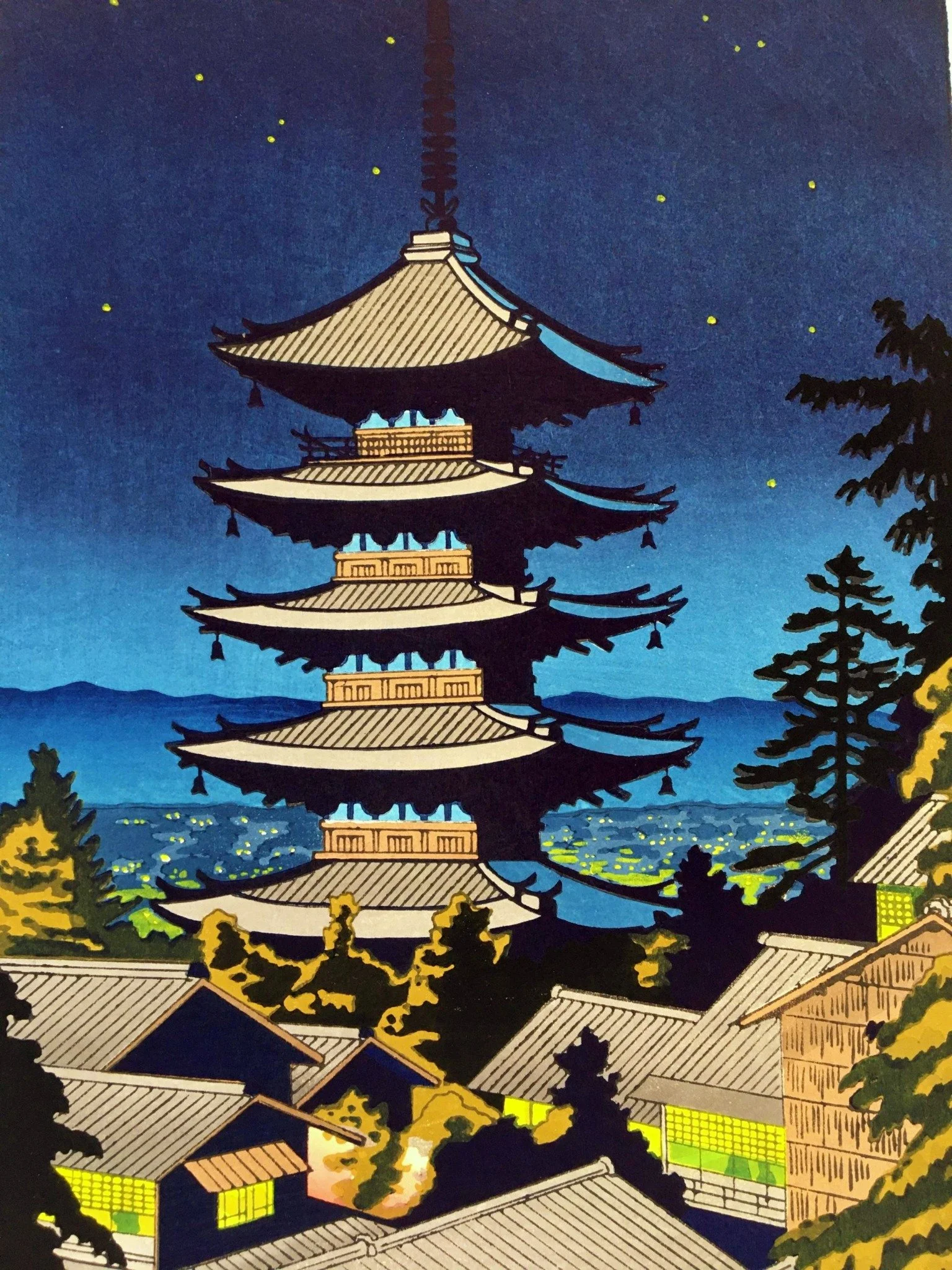 Moonlight at Yasaka Pagoda by Takeji Asano: five-storey pagoda with pale roofs in a deep blue starry sky, dark pines, distant city lights and foreground houses with glowing yellow-green windows.
