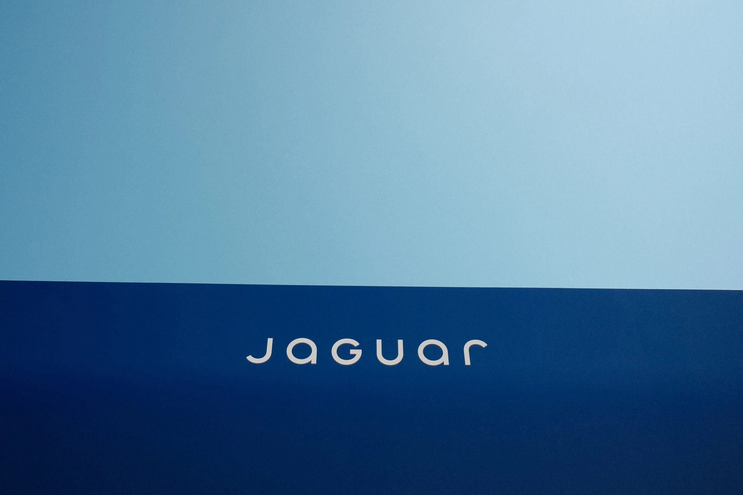 Minimalist Jaguar logo displayed on a blue installation at the Goodwood Festival of Speed.
