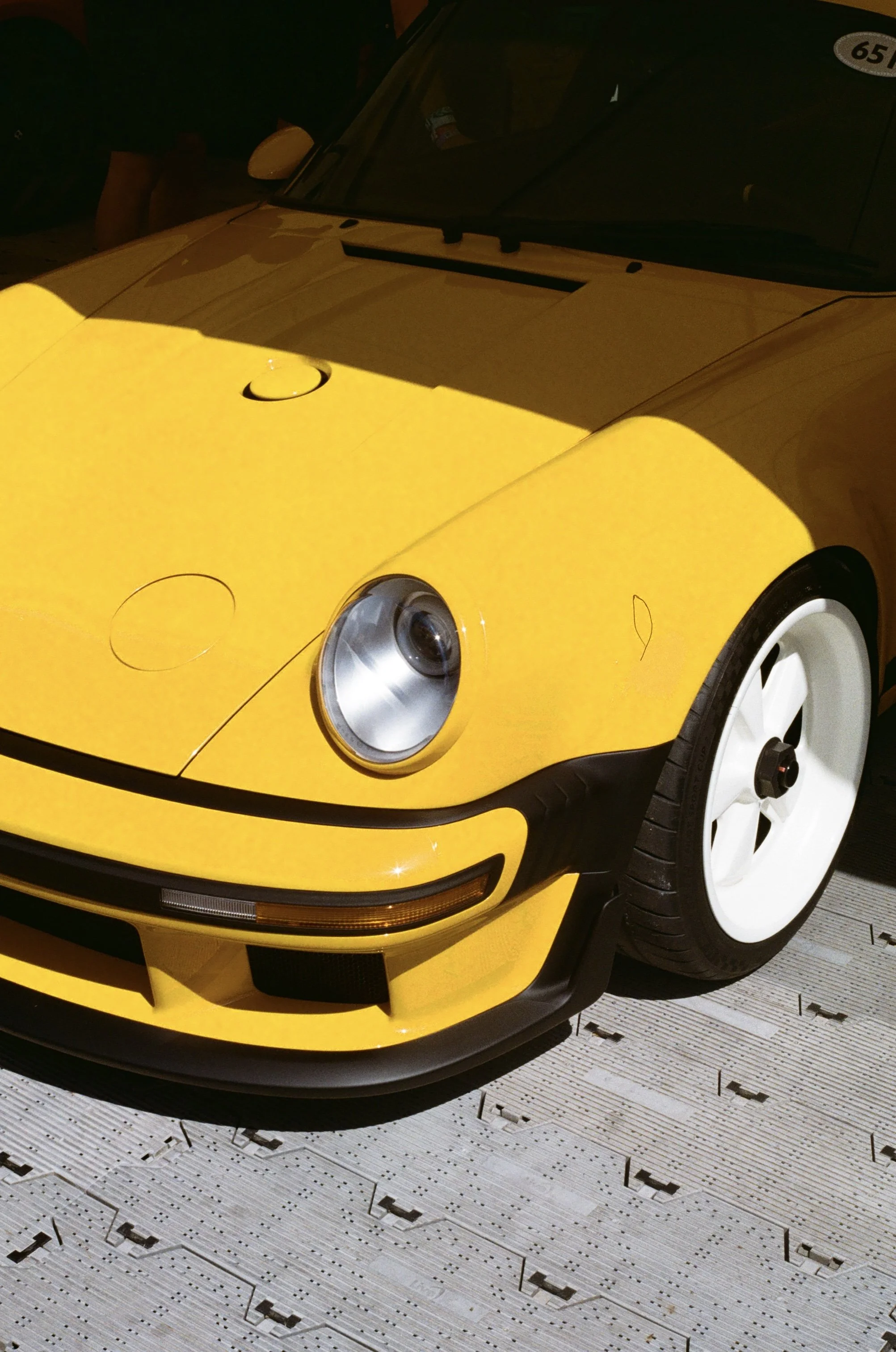 ellow Singer Porsche 911 photographed at the Goodwood Festival of Speed in dramatic sunlight.