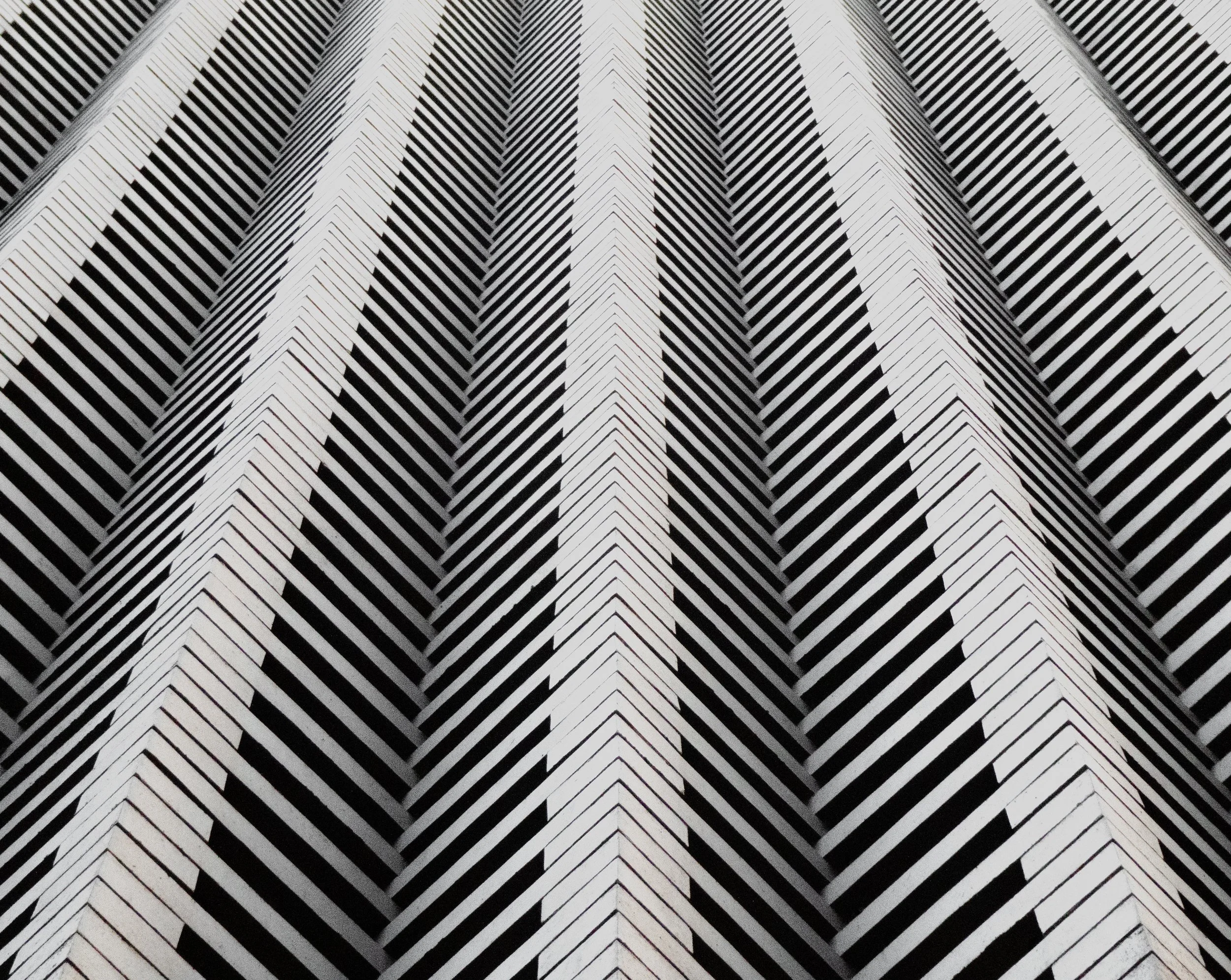 Black and white abstract pattern of diagonal stripes forming a chevron design.