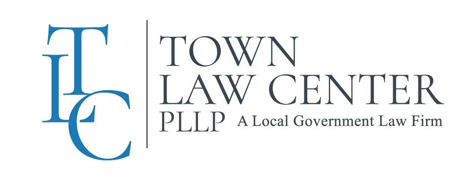 Logo for Town Law Center PLLP, a local government law firm, featuring blue initials 'TLC' and the firm’s name in black text.
