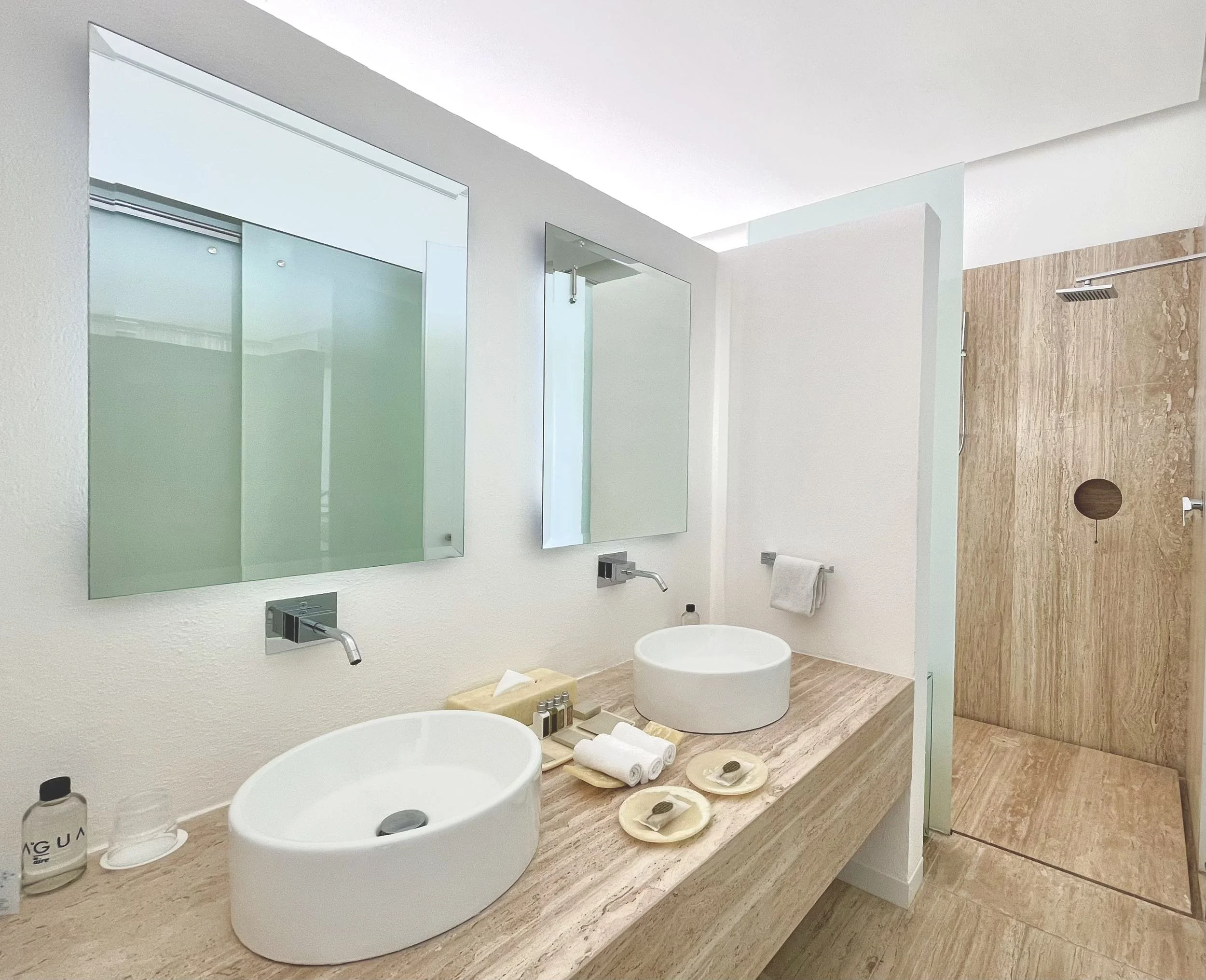 Área de lavabos geométricos en el baño de la Ocean Balcony Suite en Hotel Encanto. Espacio sofisticado a escala humana.