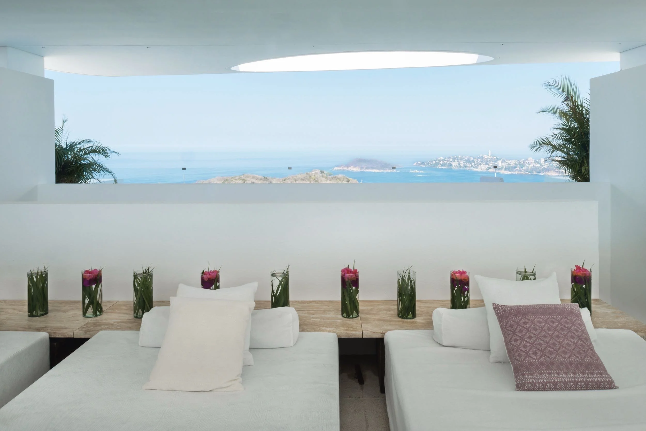 Terraza de contemplación con sillones blancos frente al océano Pacífico en Encanto Acapulco, Brisas Marqués.