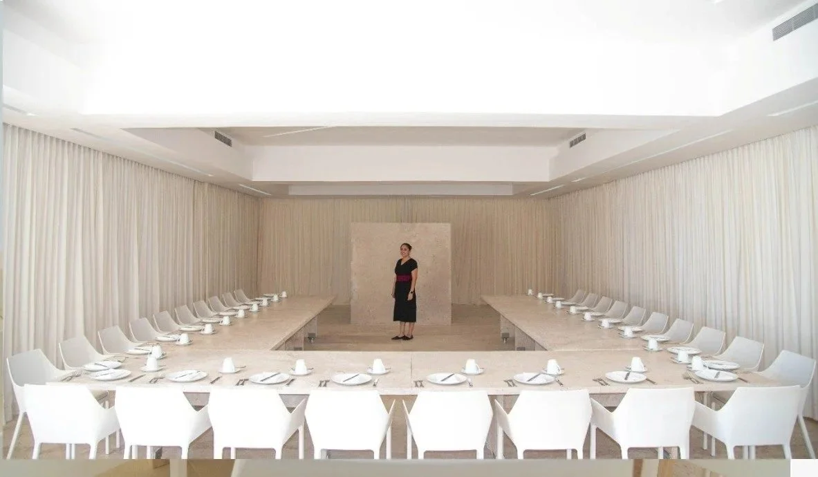 Salón de eventos corporativos con mesa en U, sillas blancas y cortinas sutiles en Hotel Encanto Acapulco.