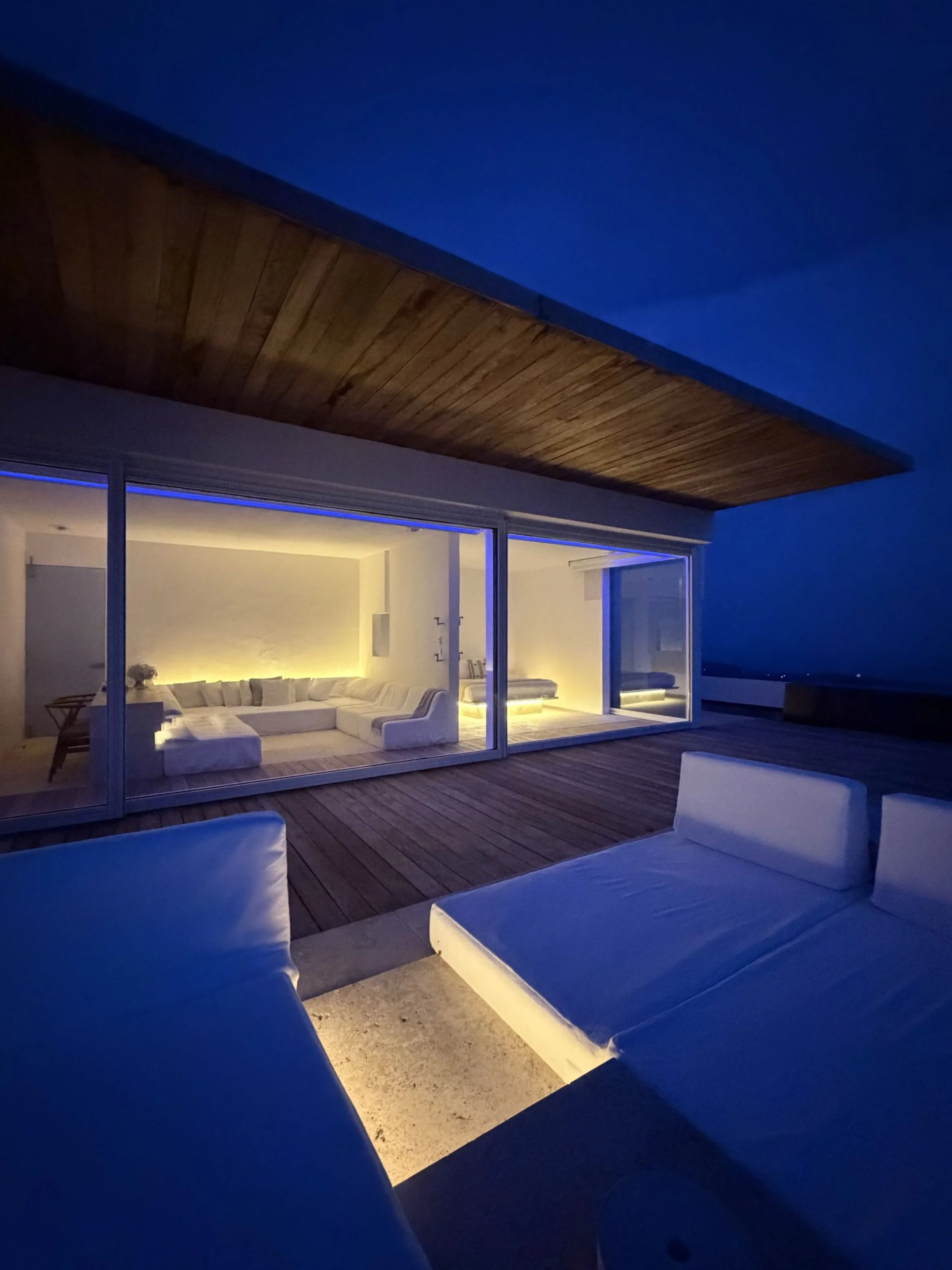 Habitación y terraza con vista nocturna en terraza de Signature Suite de Hotel Encanto. Espacio exterior iluminado con tonos cálidos y azules. 