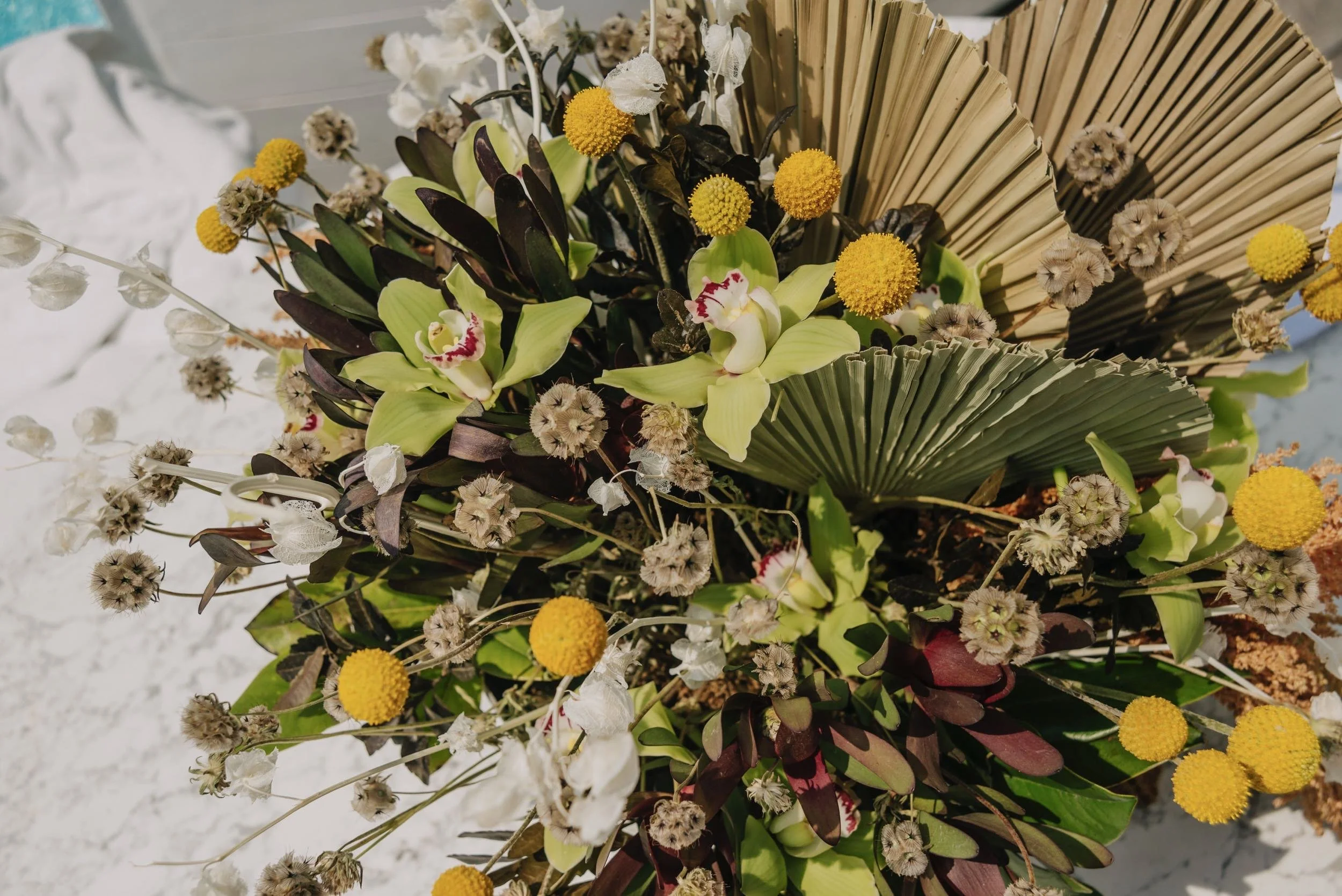 Arreglo floral con vegetación local en banquete de Hotel Encanto Acapulco. Integración sutil con el entorno salvaje.