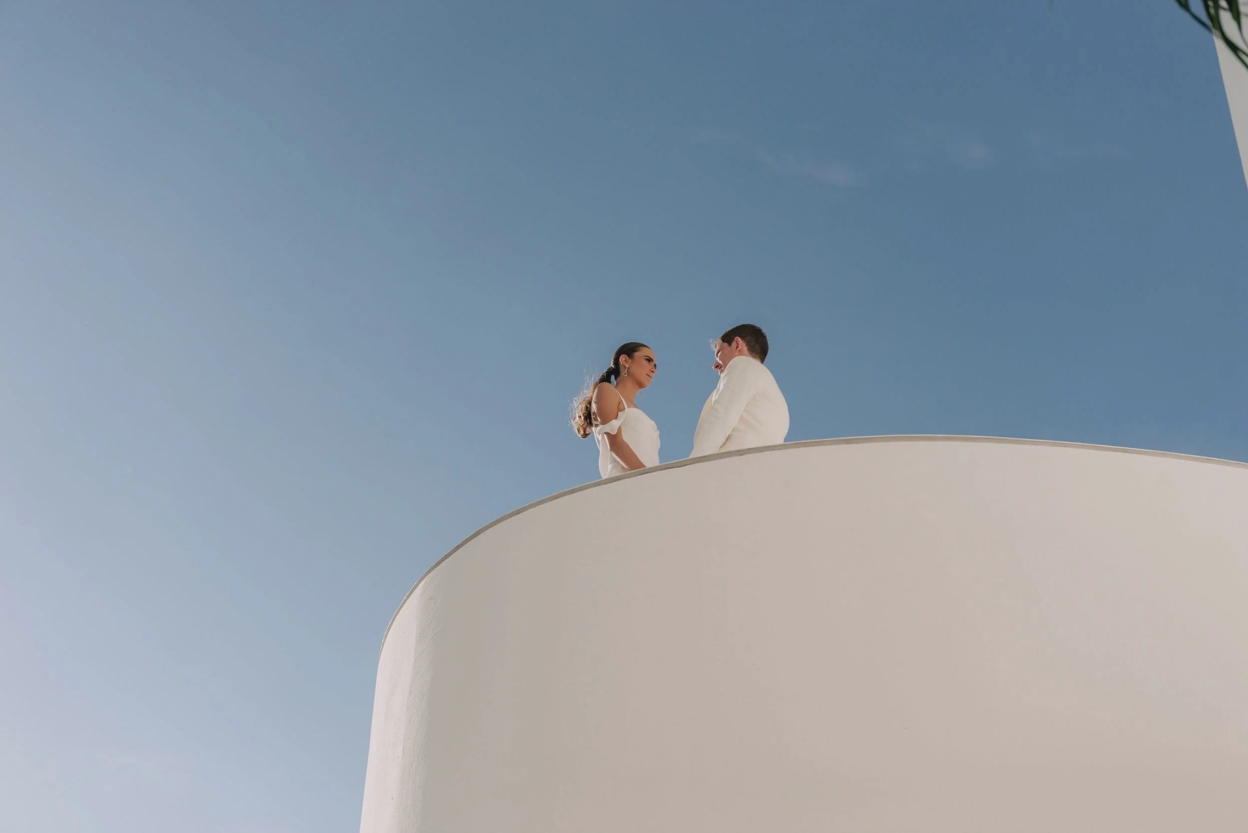 Pareja sobre la estructura monolítica blanca de Hotel Encanto Acapulco. Arquitectura y escala humana de Taller Aragonés.