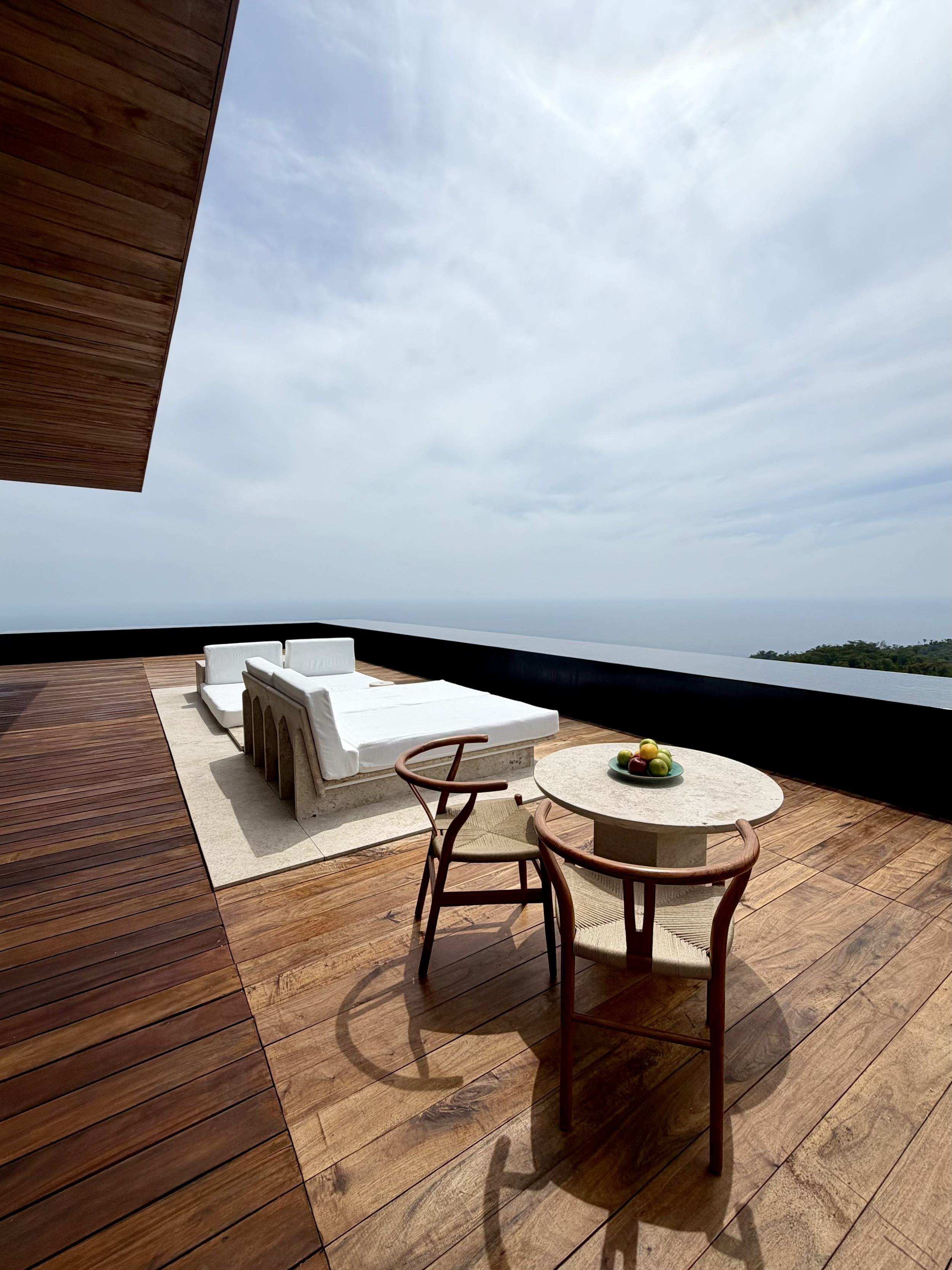 Mesa de desayuno en Terraza en Signature Suite de Hotel Encanto. Espacio exterior con vista 180 grados hacia el mar de cortes y espejo de agua perimetral con el cielo de fondo. 