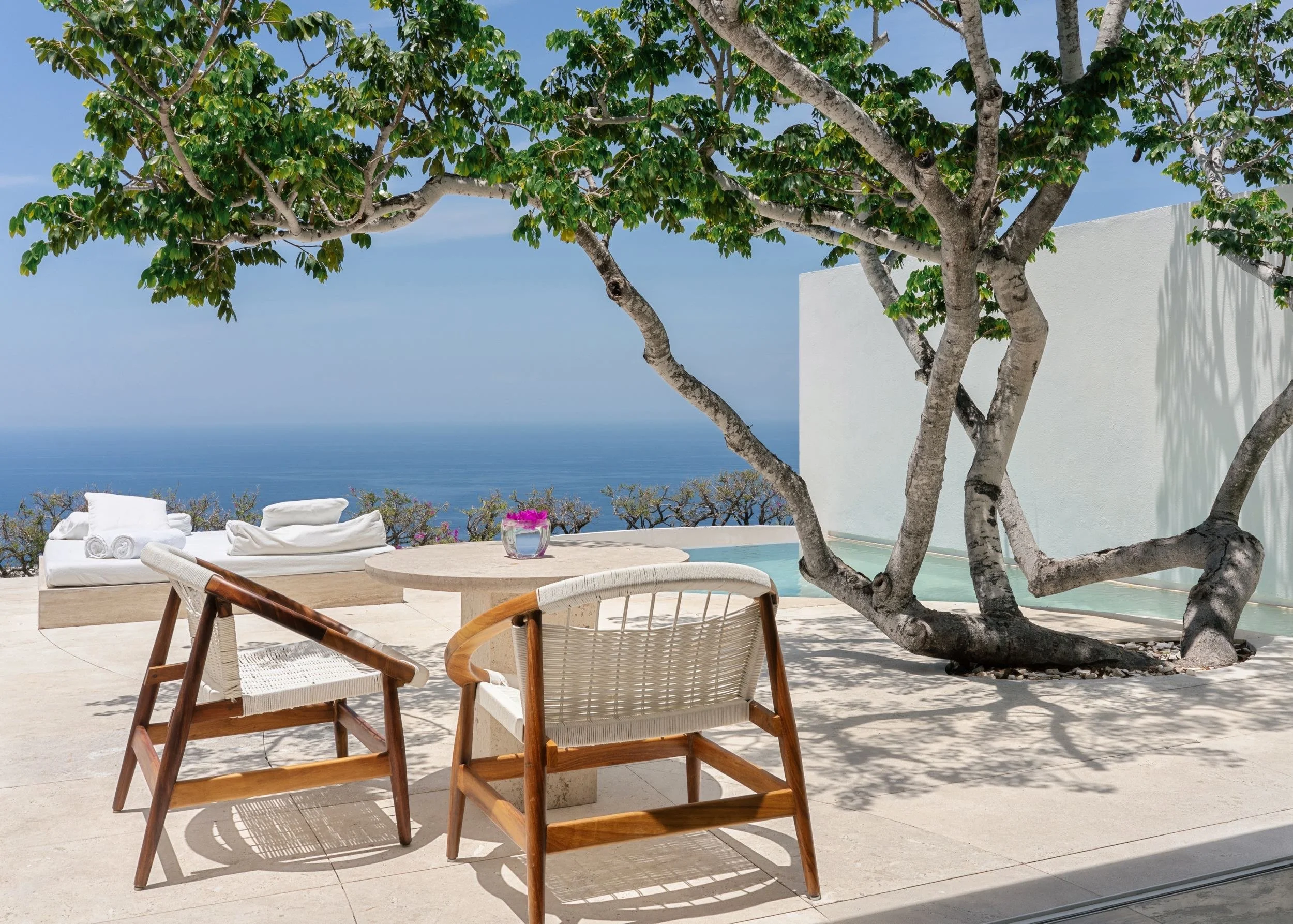 Terraza de Ocean Pool Villa en Hotel Encanto Acapulco al alba. Sillas de cara al océano y a la pulsión por el mar.