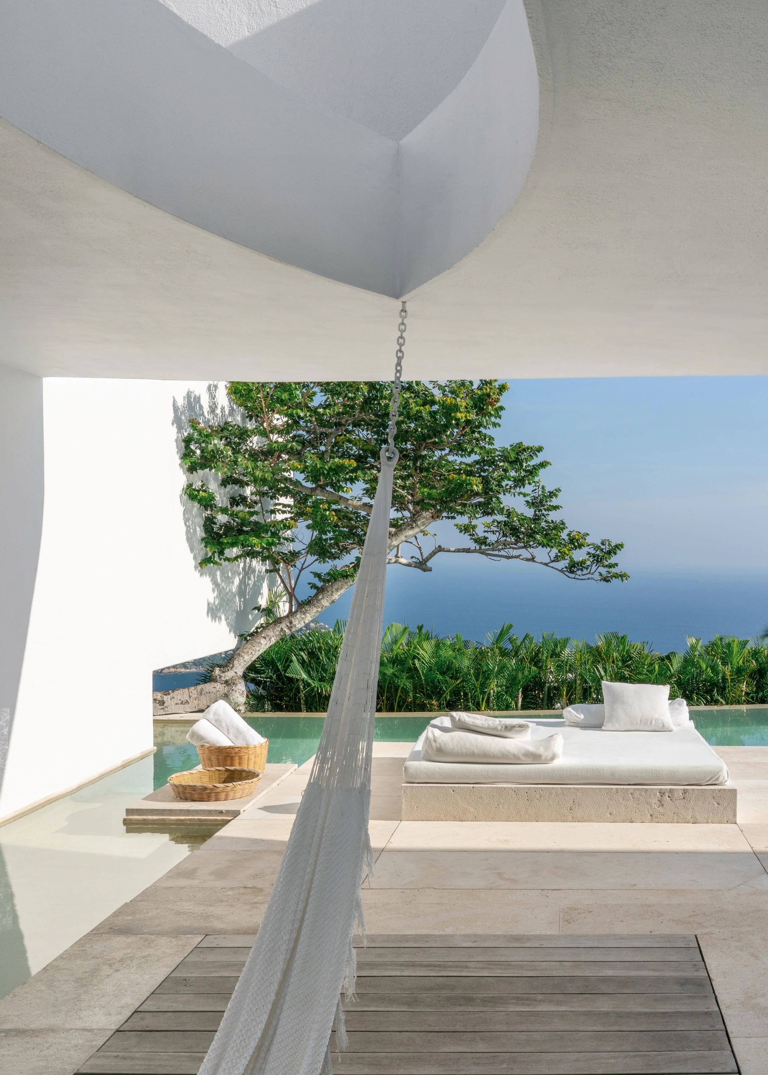 Hamaca y piscina en Terraza privada de diseño moderno frente al mar en una suite exclusiva de Encanto Acapulco.