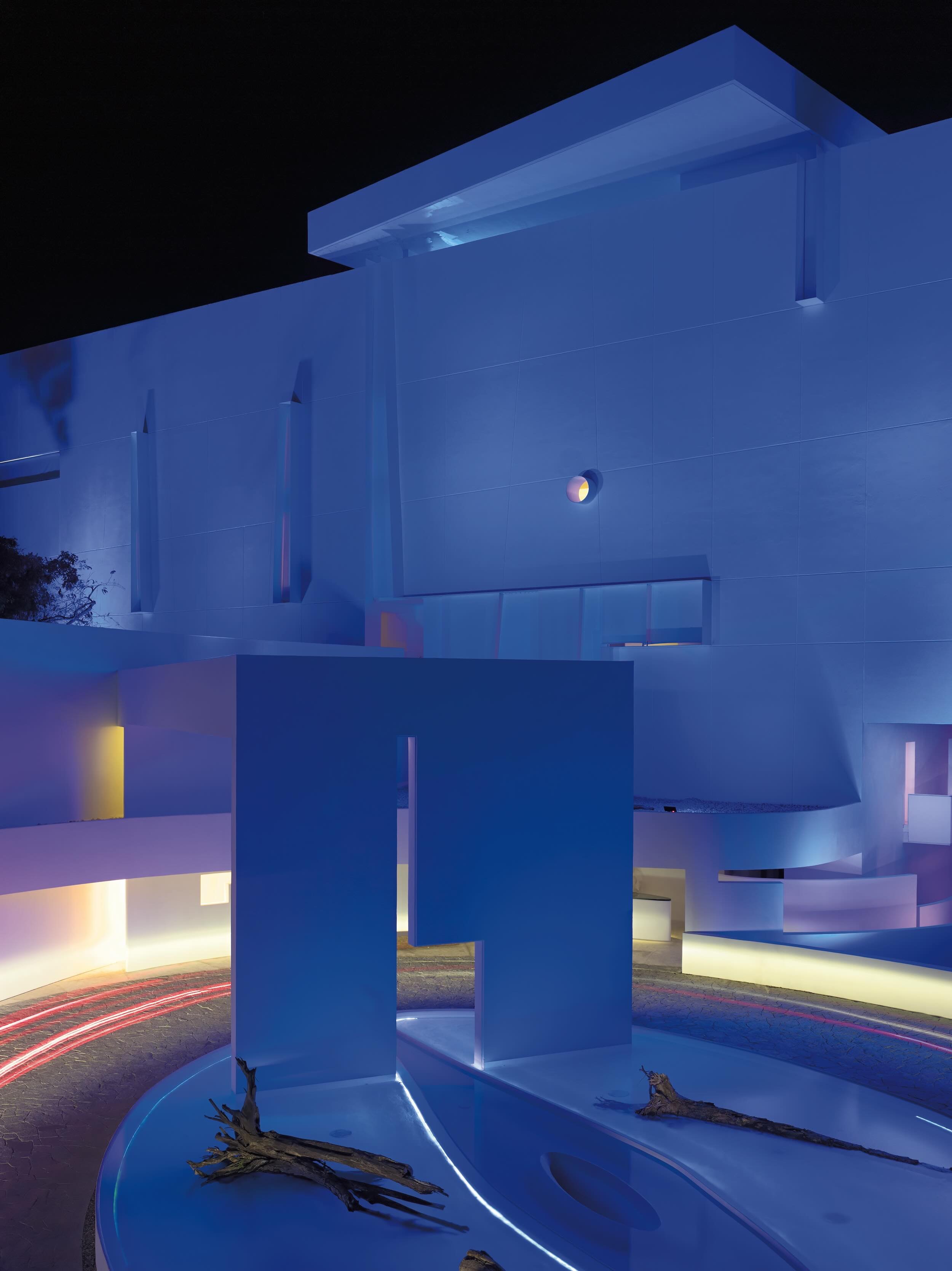 Iluminación artística cromática en la fachada monumental del hotel de diseño Encanto Acapulco.