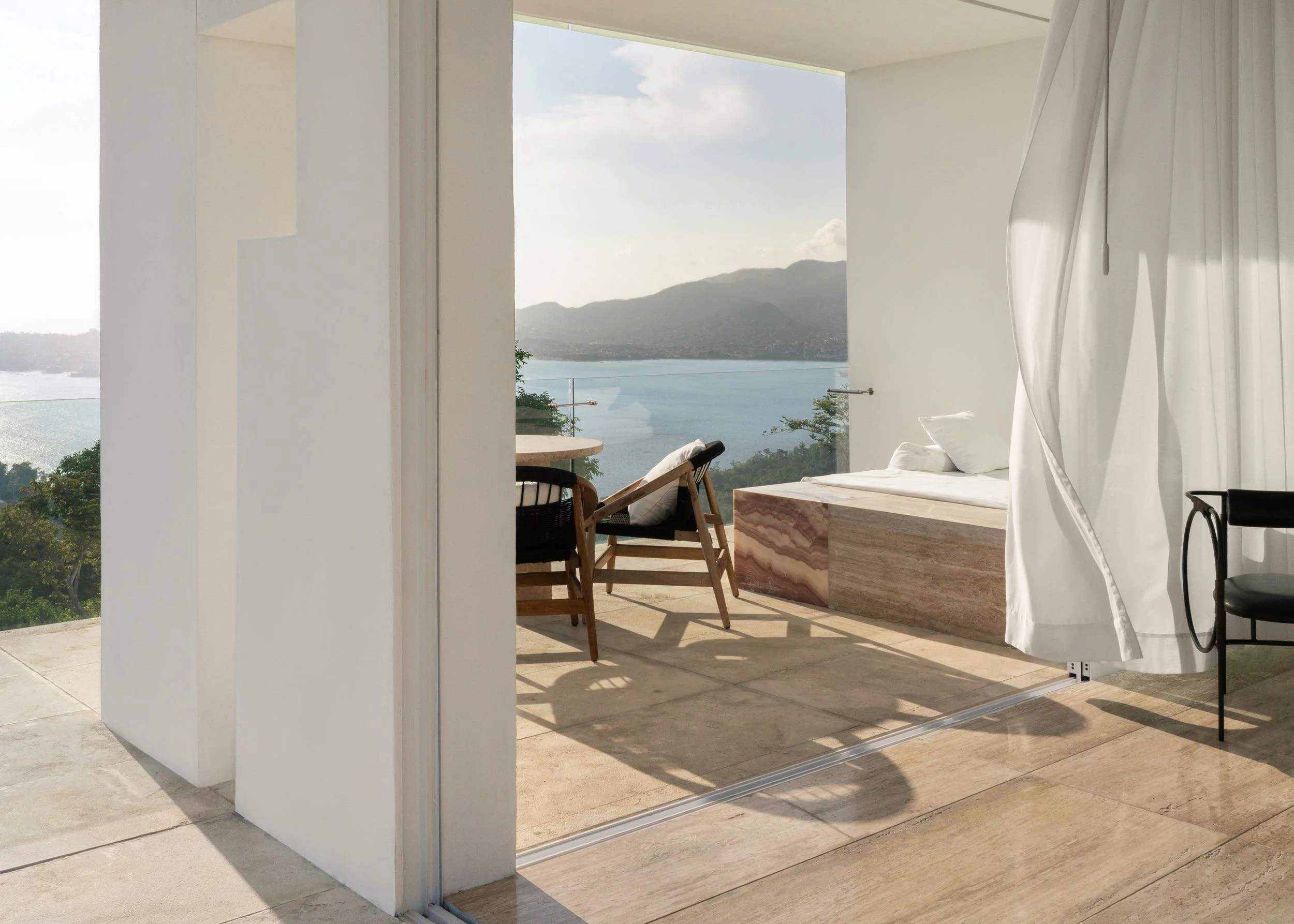 
Sillas de madera , terraza exterior, y transparencia en Ocean Designer Suite de Hotel Encanto Acapulco. Dilución de límites entre interior y mar.