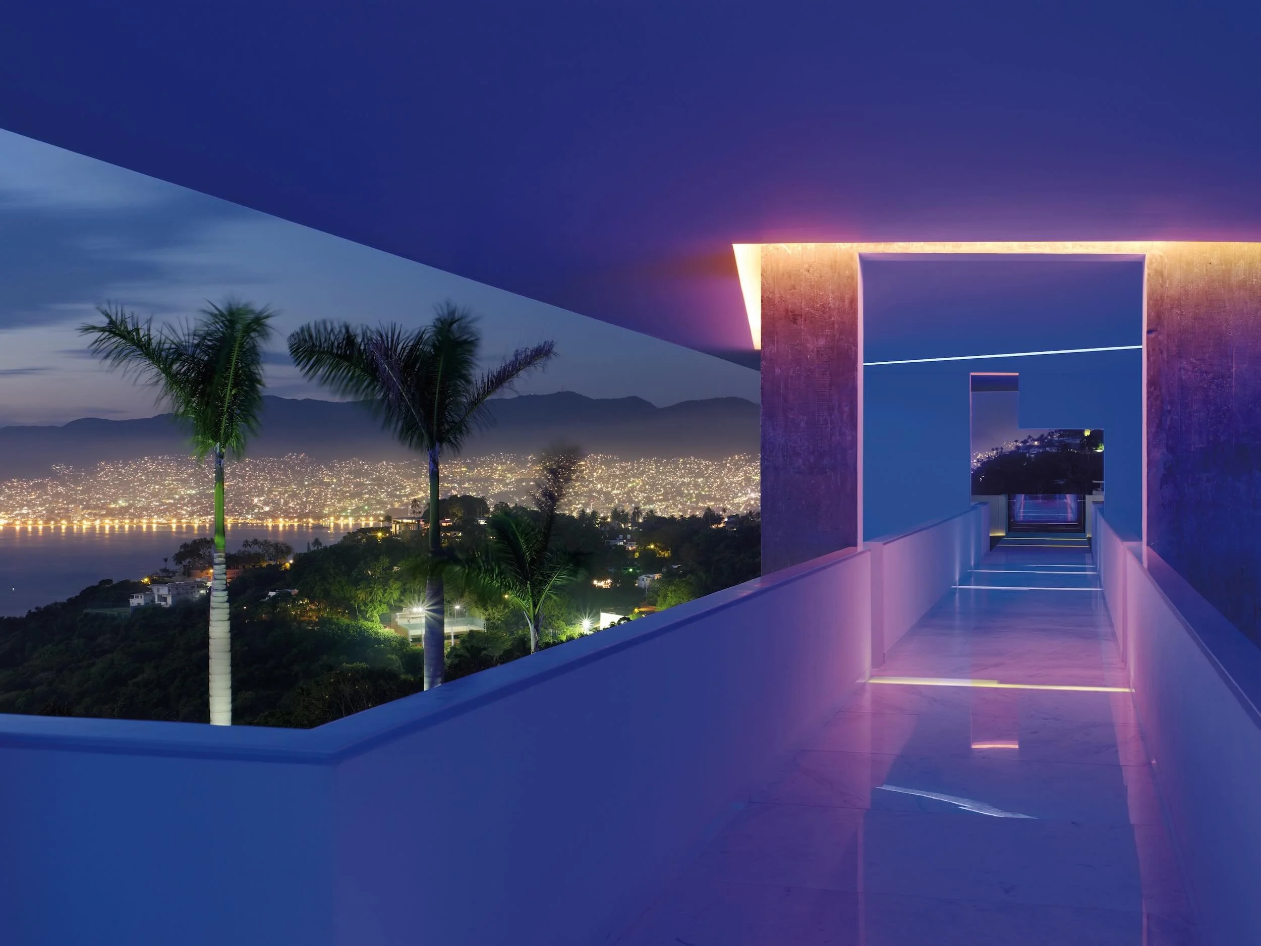 Espectacular vista nocturna a la bahía desde la alberca infinita iluminada de Encanto Acapulco.