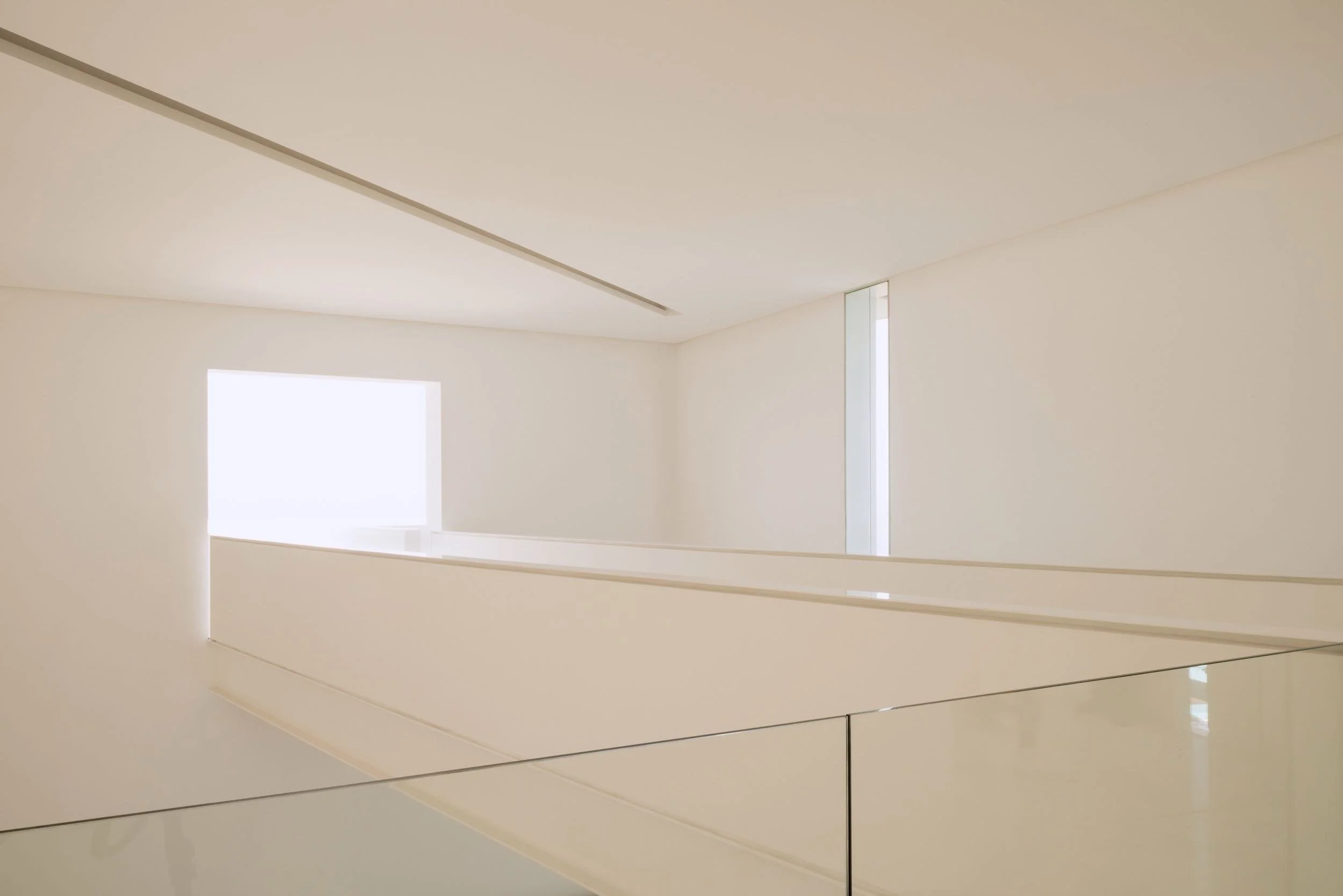 Diseño de interiores minimalista y juego de luz natural en los espacios de Hotel Encanto Acapulco. Foto por Joe Fletcher. Puente con luz cegadora al fondo. 