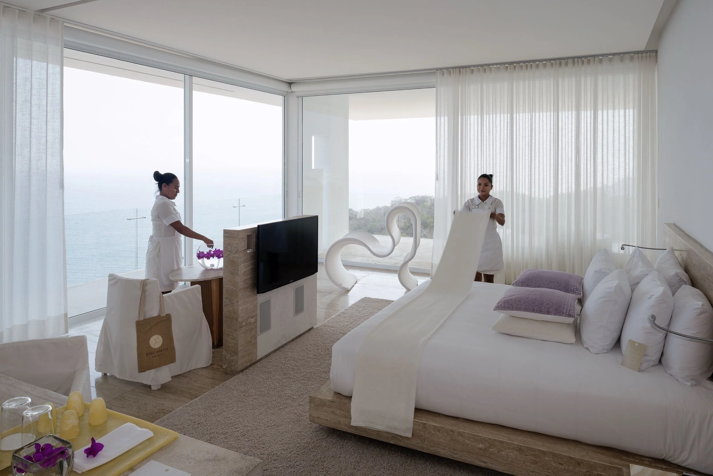 Interior minimalista de la Ocean Designer Suite en Hotel Encanto Acapulco. Ventanales abiertos hacia el Pacífico
