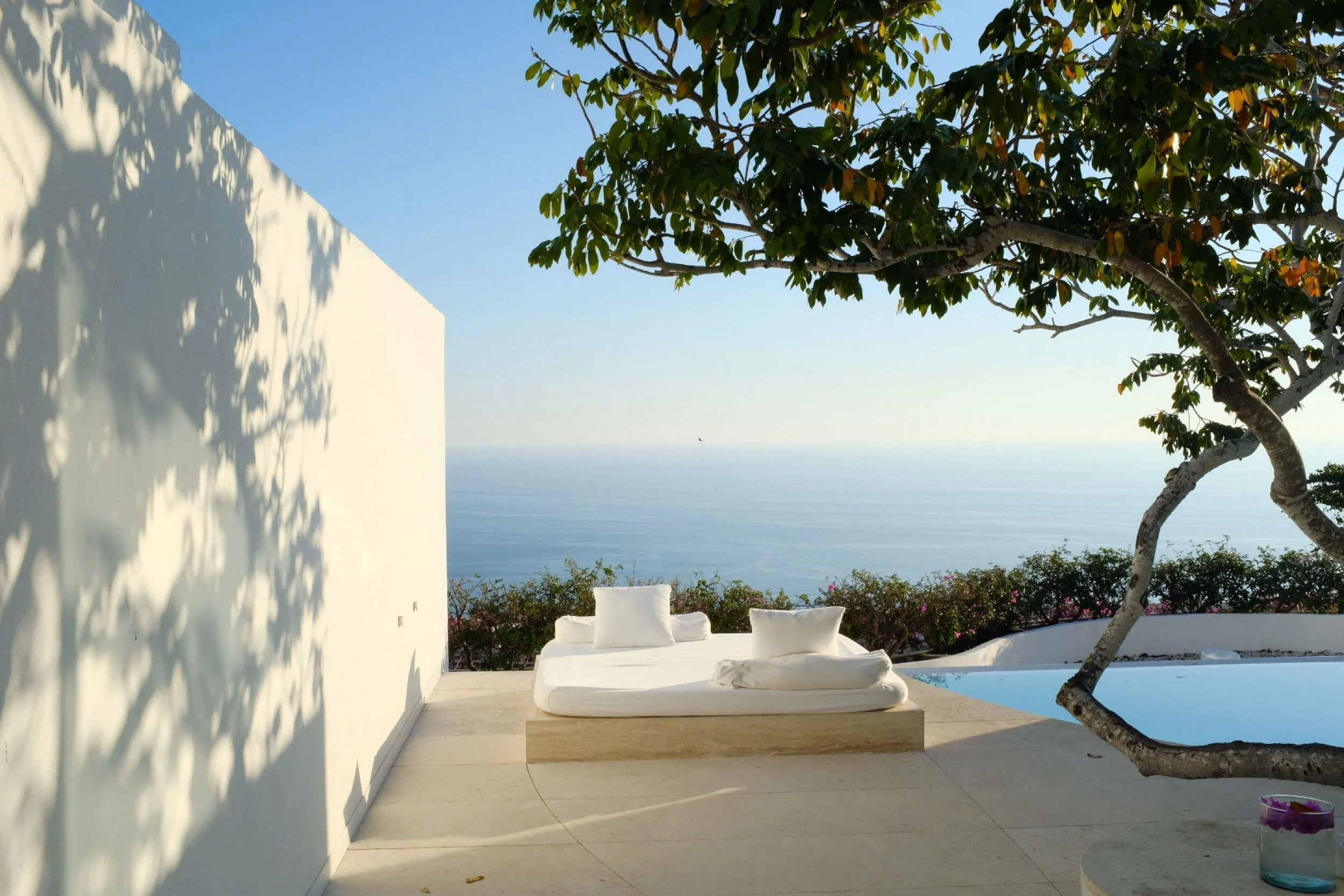 Asoleadero minimalista sobre concreto blanco en Ocean Pool Villa de Hotel Encanto. Geometría limpia en Brisas Marqués.
