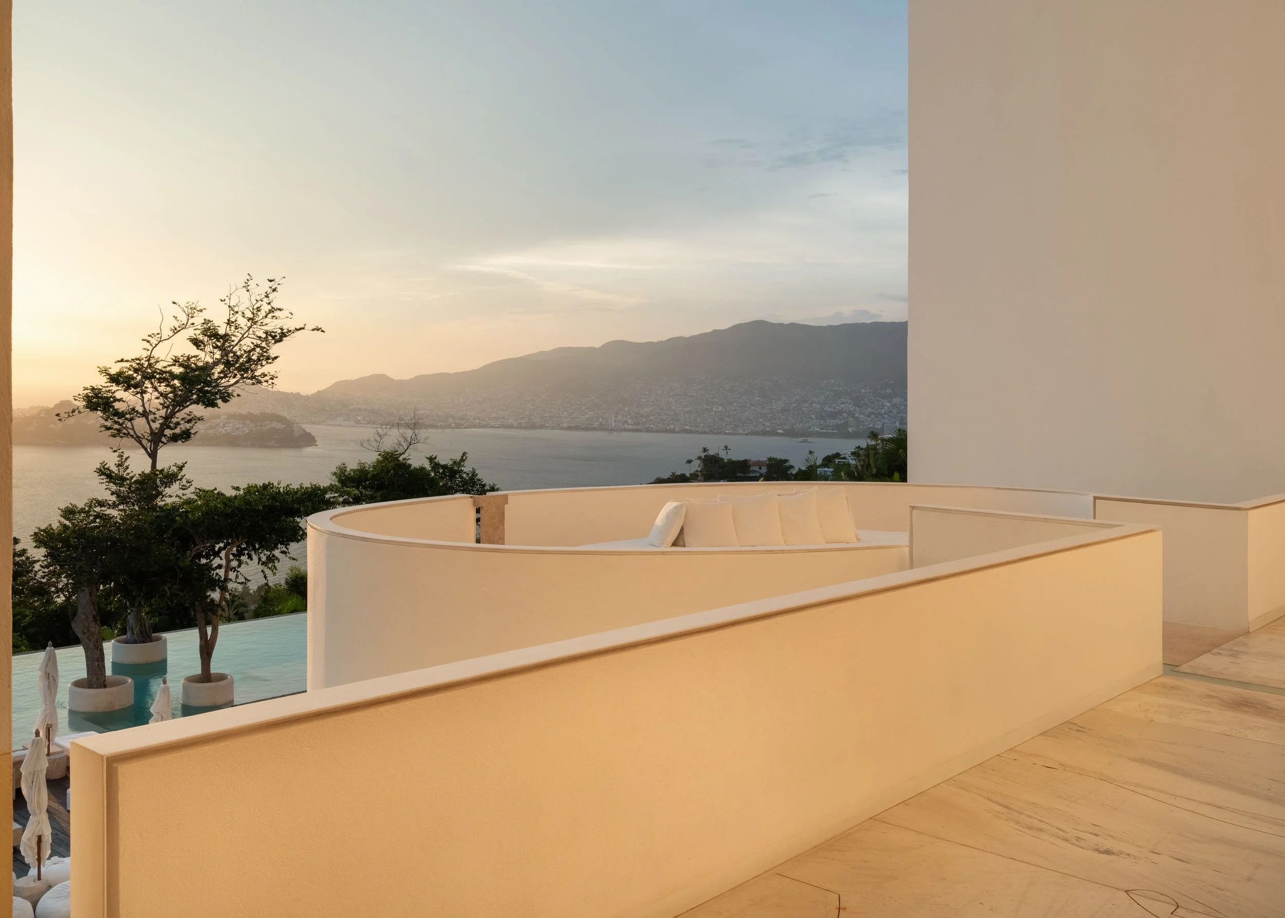 Vista hacia Bahia de Acapulco. Sofa en terraza minimalista de materiales austeros y diseño de autor en el hotel boutique Encanto Acapulco. Arquitectura Taller Aragonés