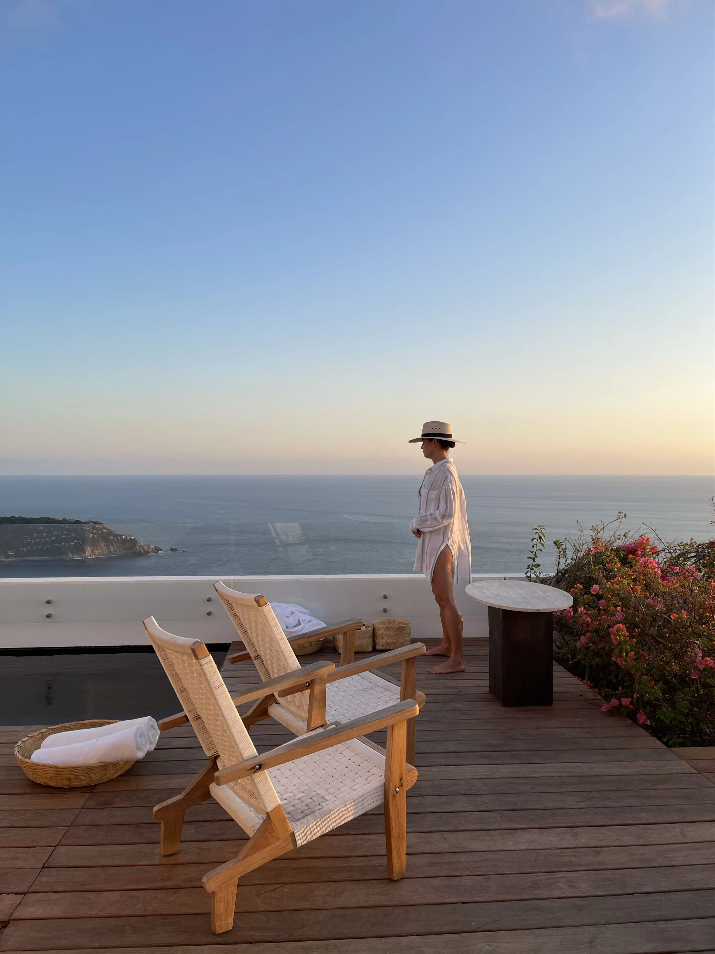 Contemplación mística del amanecer desde los camastros de madera en el área exterior de Encanto Acapulco. 