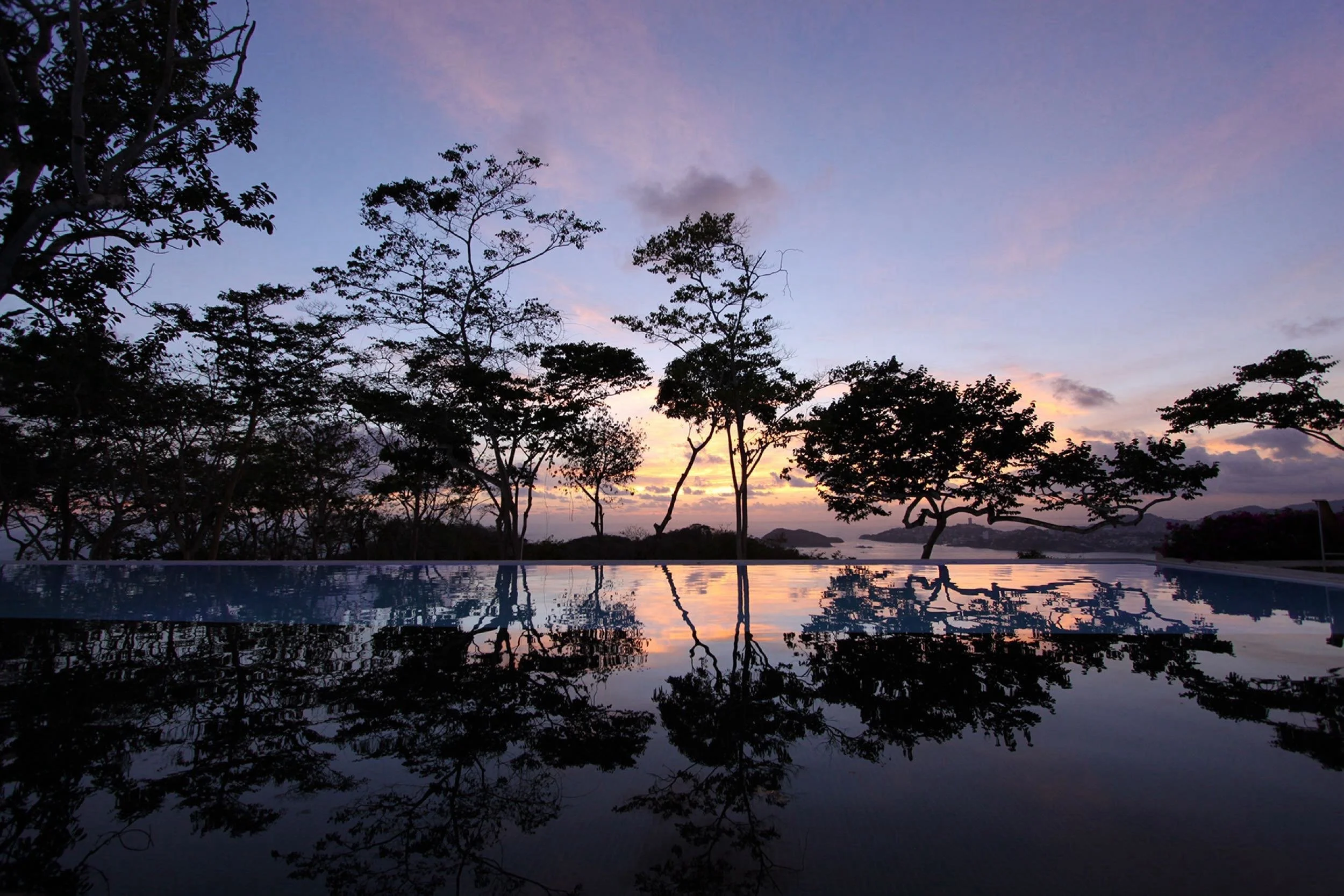 Espejo de agua al atardecer en el resort de diseño Encanto Acapulco, sintonía entre espacio y naturaleza.