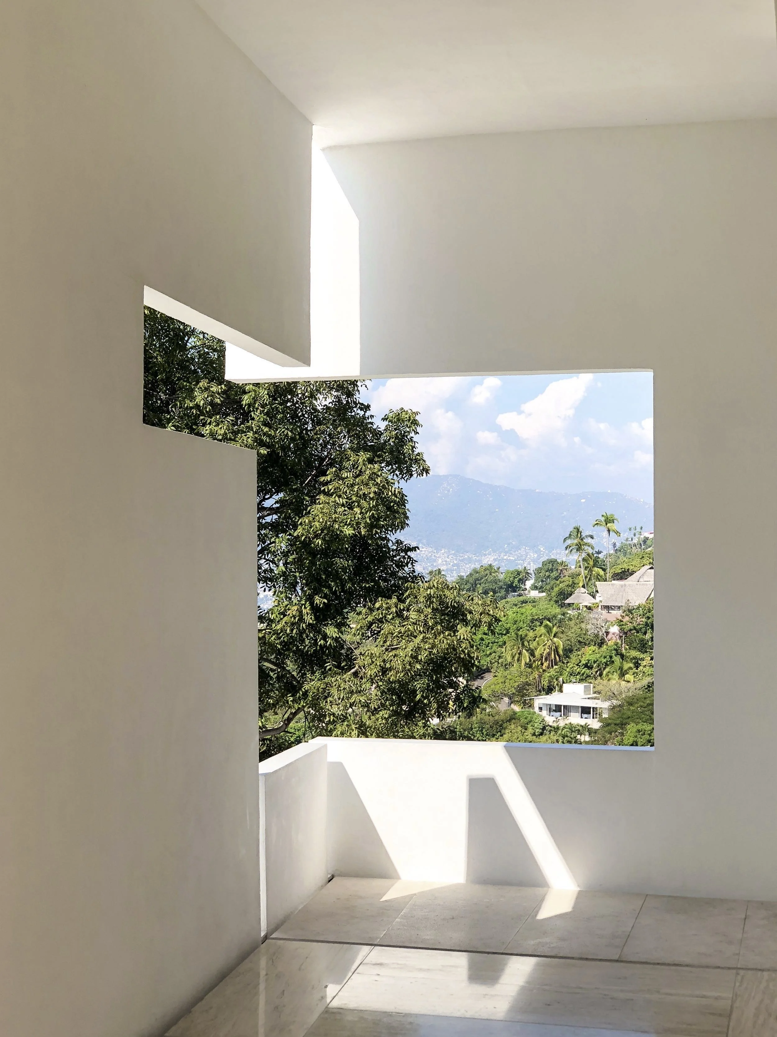 Encuadre arquitectónico monolítico que atrapa la vista de Brisas Marqués a través de un vano geométrico.
