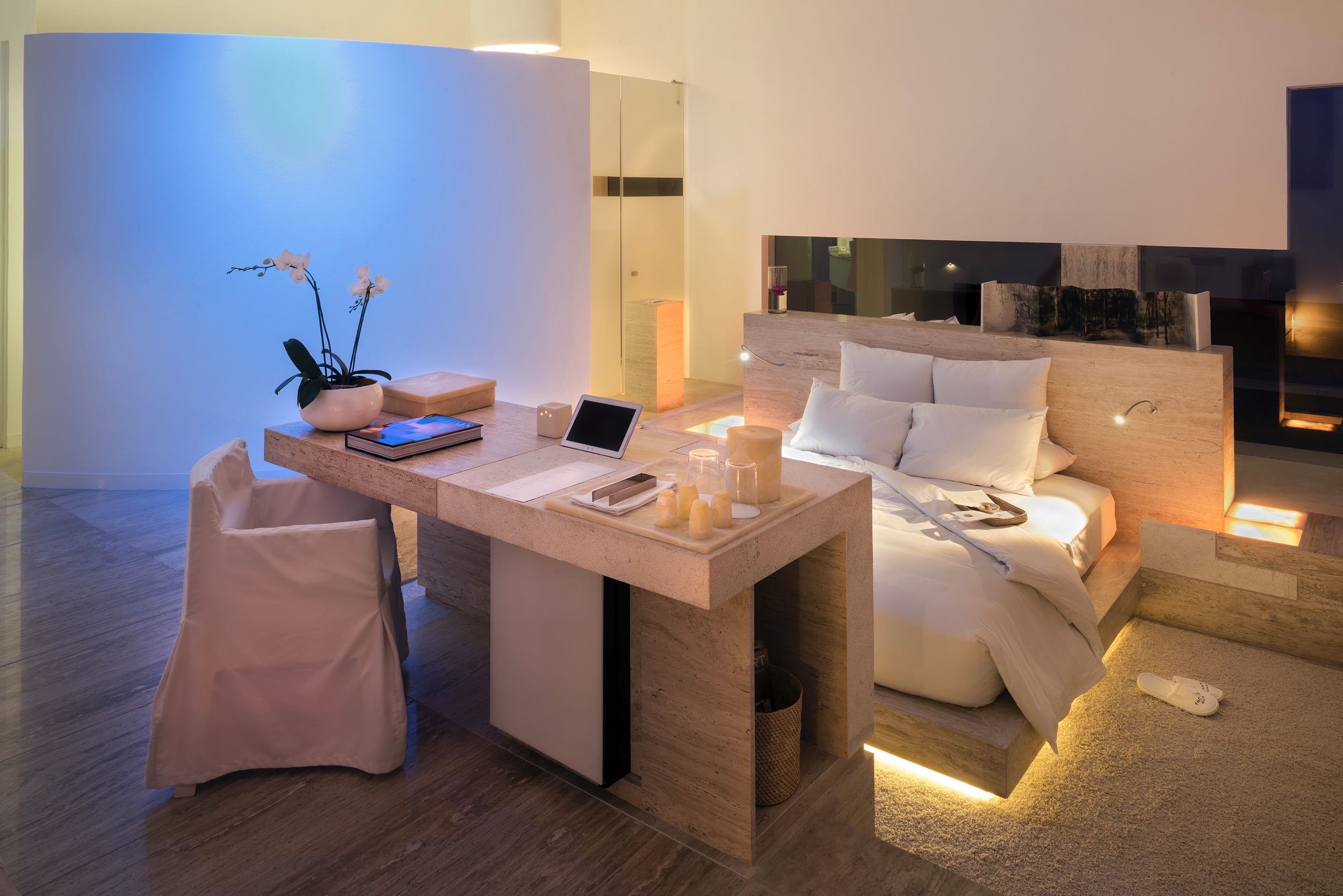 Luz cálida indirecta bajo el mobiliario en Ocean Encanto Villa de Hotel Encanto. Arquitectura emocional al anochecer.