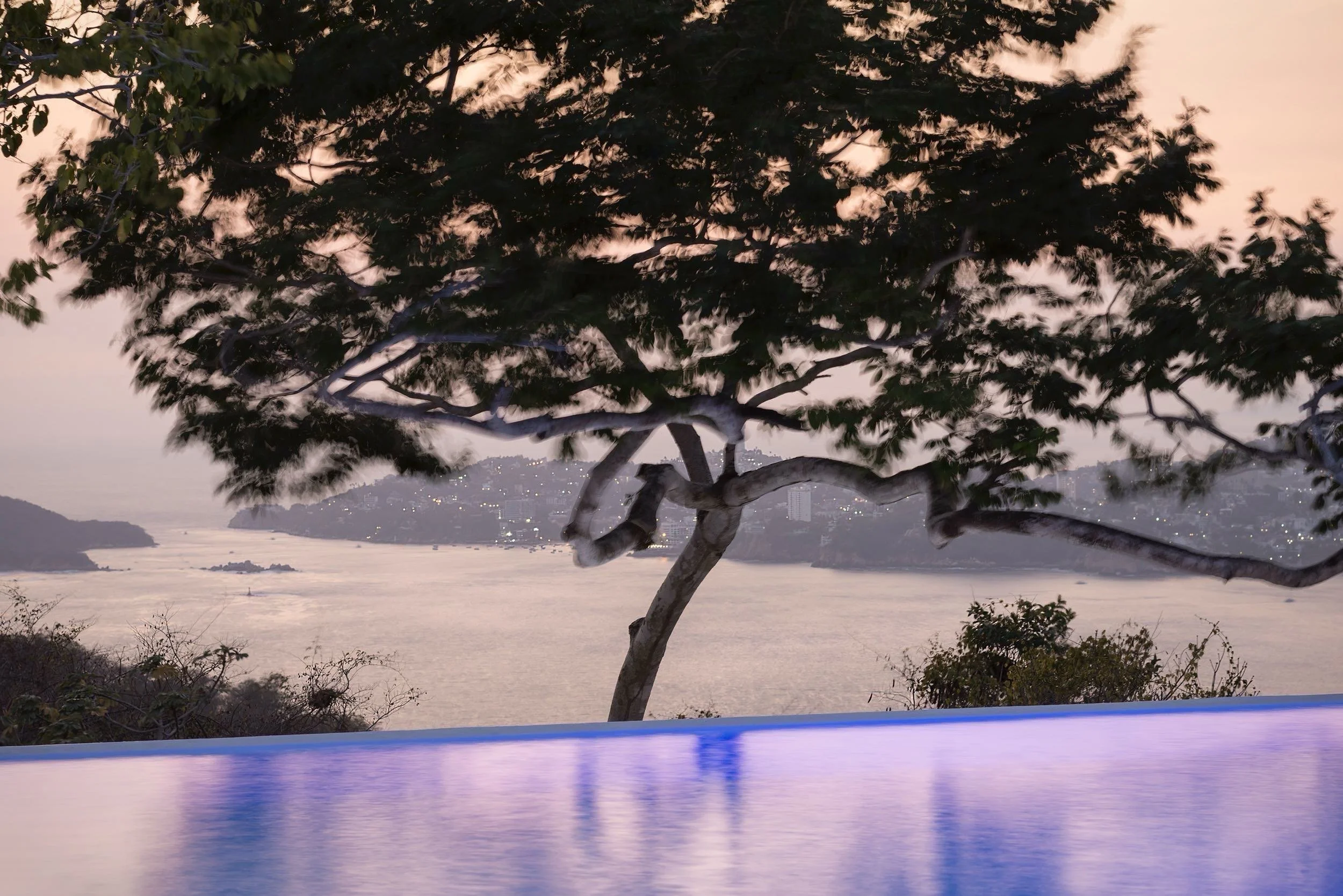 Terraza exclusiva con vista panorámica al mar Pacífico en el resort boutique Encanto Acapulco. Fotografía de Joe Fletcher. Agua con color purpura.