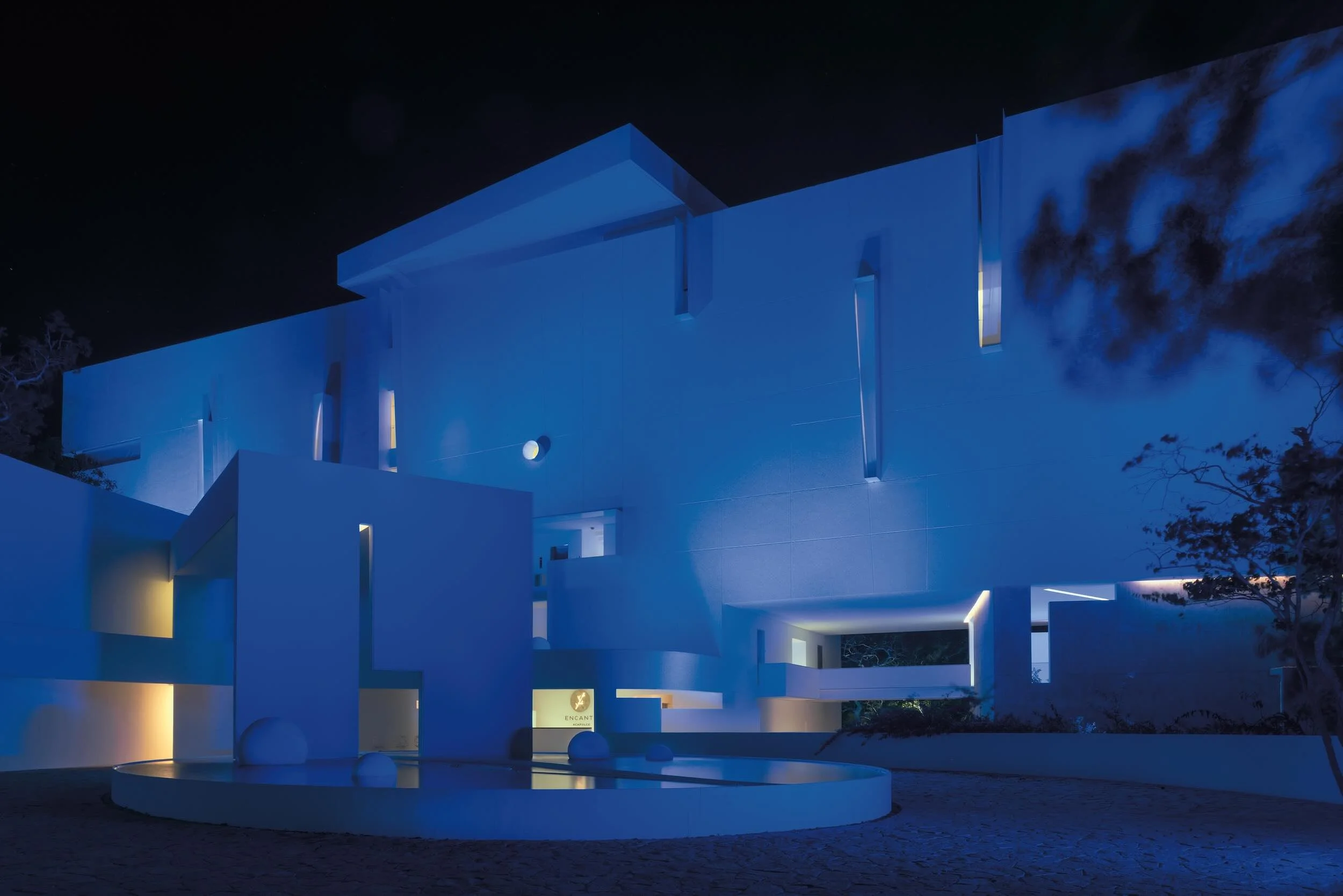 Iluminación artística nocturna y diseño cromático en las instalaciones de lujo de Hotel Encanto Acapulco. Fotografía de Nicola Lorusso. Estructura geometrica con calados abstractos. 