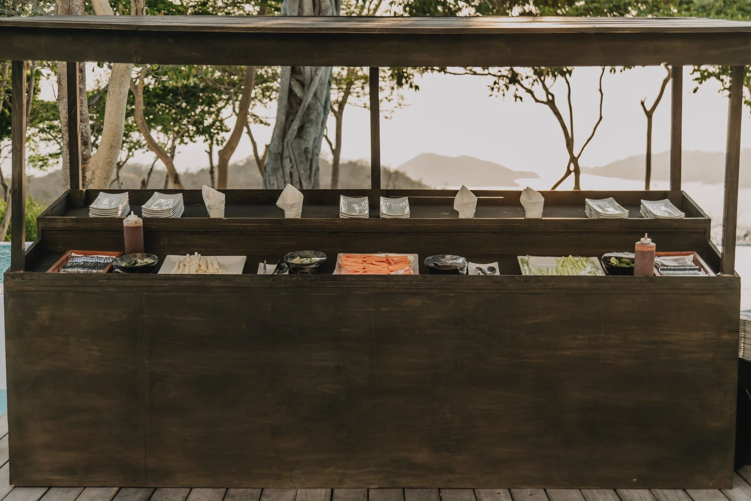 Barra de cócteles al aire libre bajo la vegetación tropical en Hotel Encanto Acapulco. Espacios puristas para eventos.