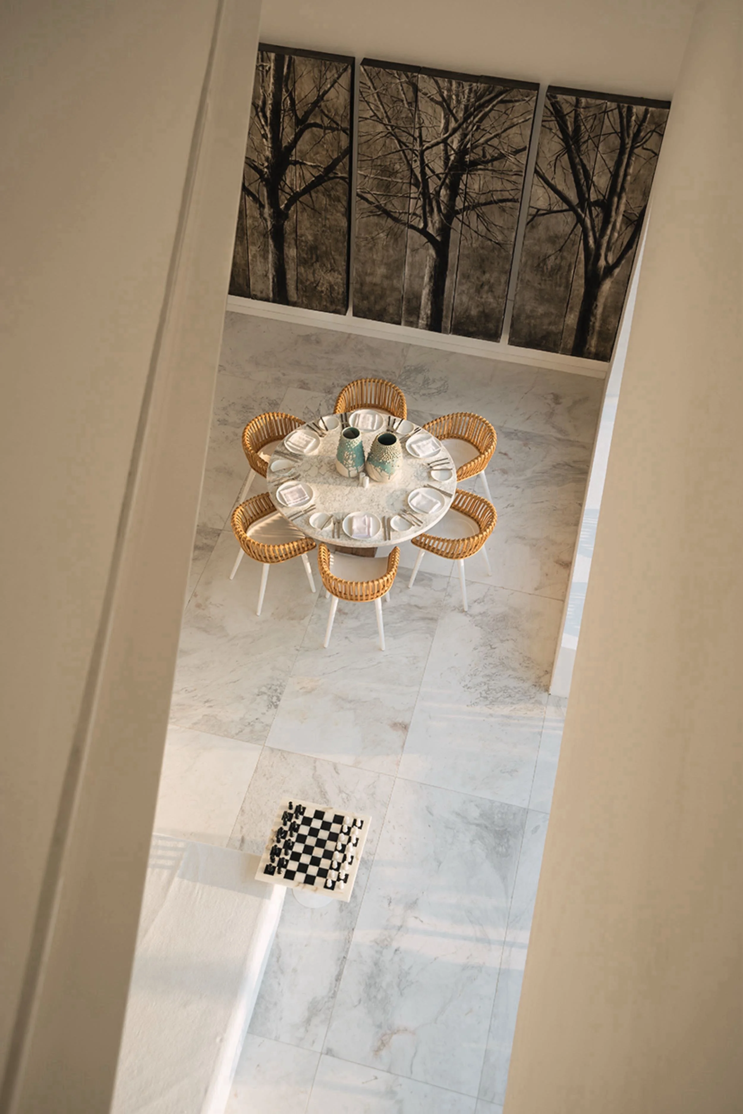 Perspectiva aérea de un comedor minimalista con texturas naturales, integrado a la escala humana del espacio.