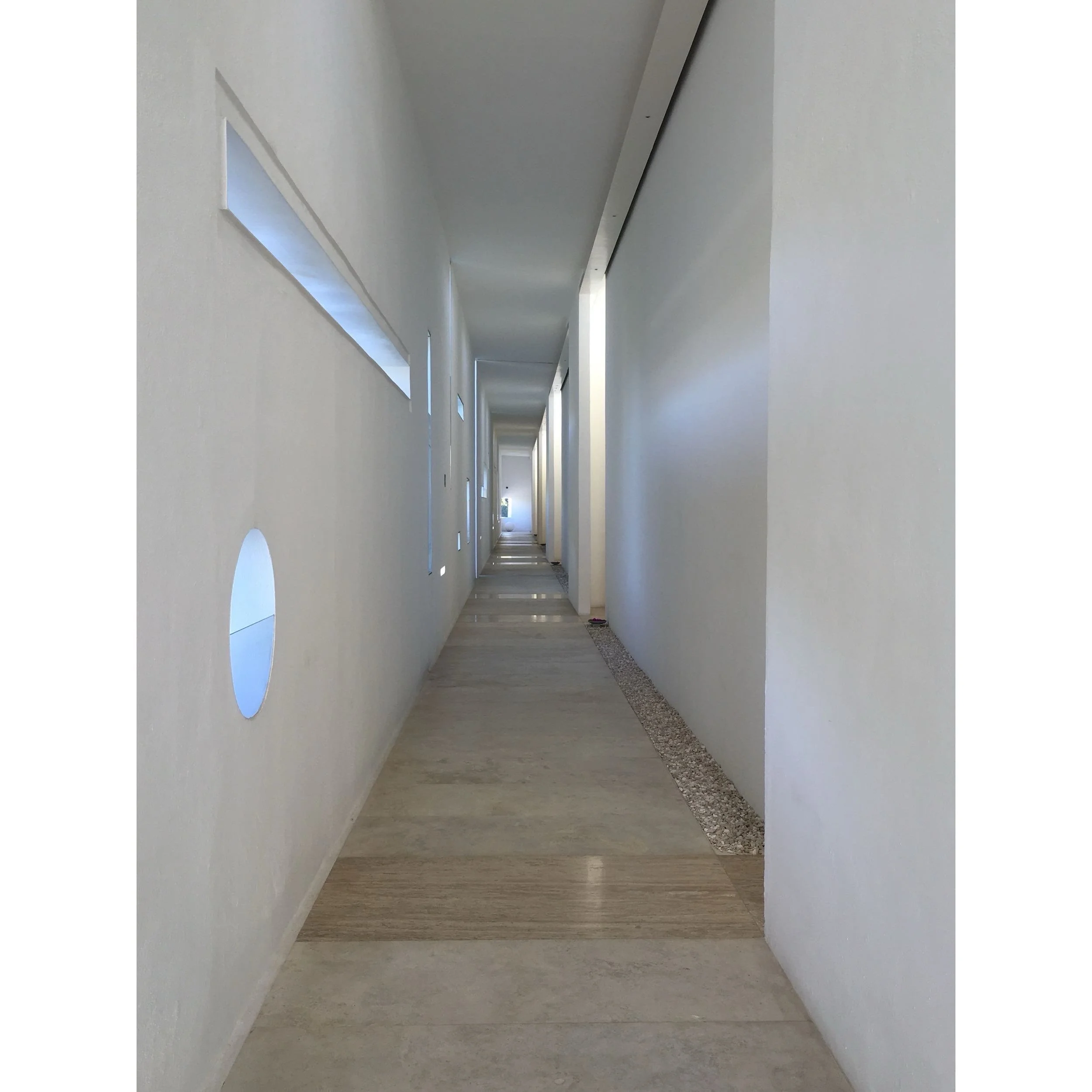 Diseño de interiores minimalista y juego de luz natural en los espacios de Hotel Encanto Acapulco. Foto por Nicola Lorusso. Pasillo con materiales austeros y claros. 