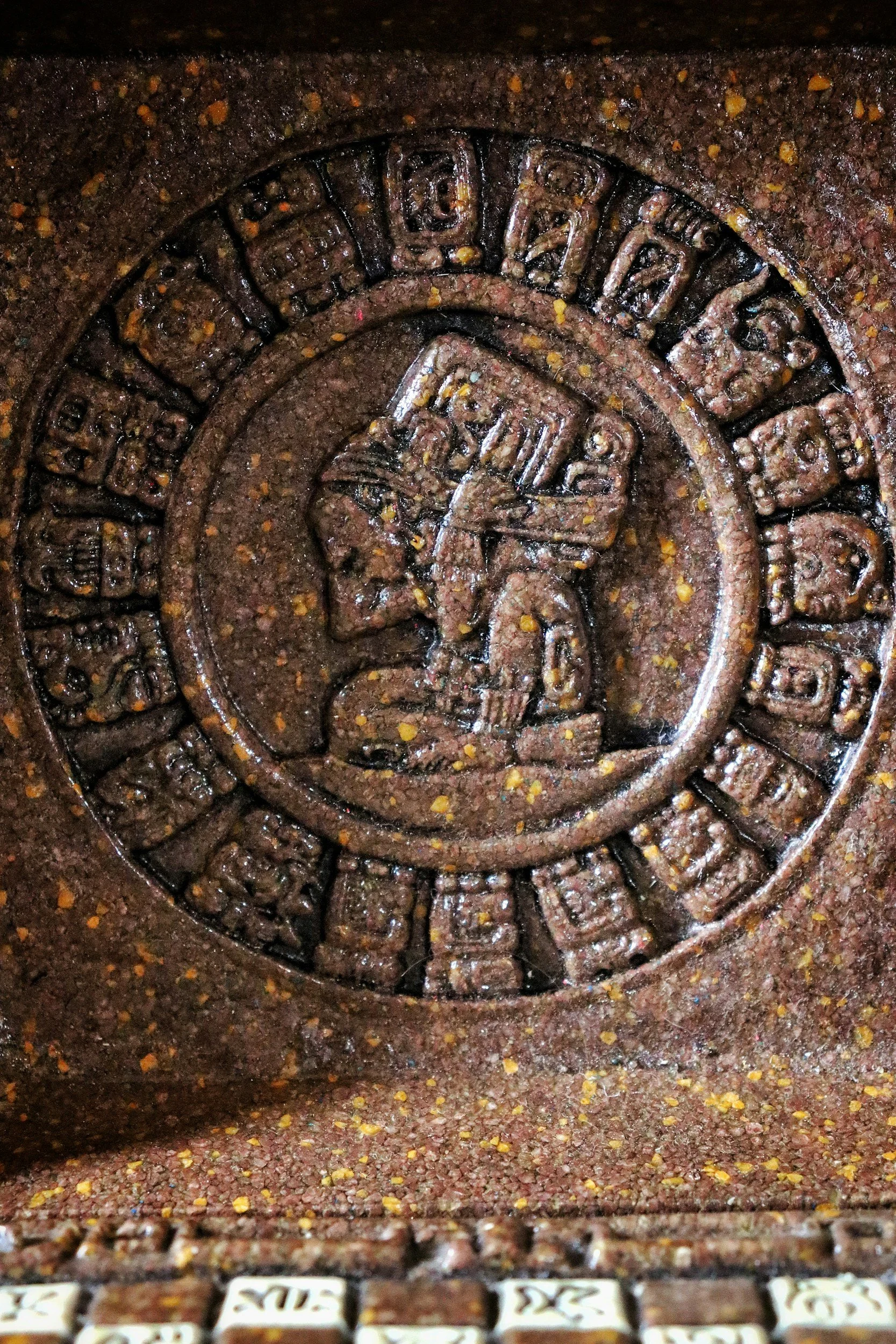 Close-up of an antique Zodiac-themed engraved metal compass or watch face with intricate details and wording around the edge.