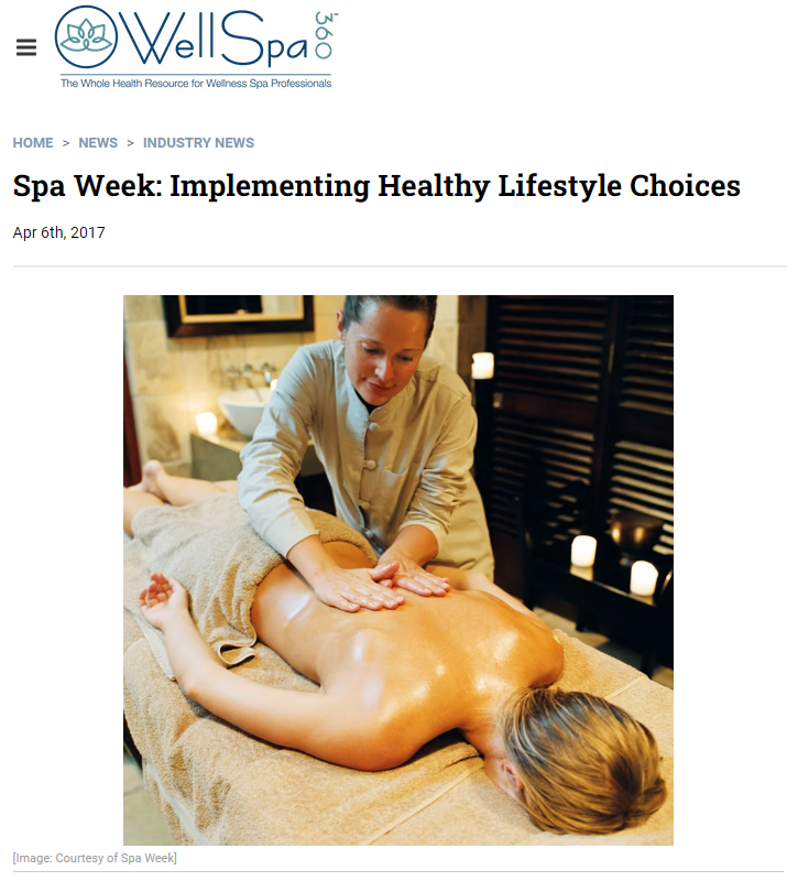 A woman receiving a hot stone massage at a spa, lying face down on a massage table with hot stones placed on her back.
