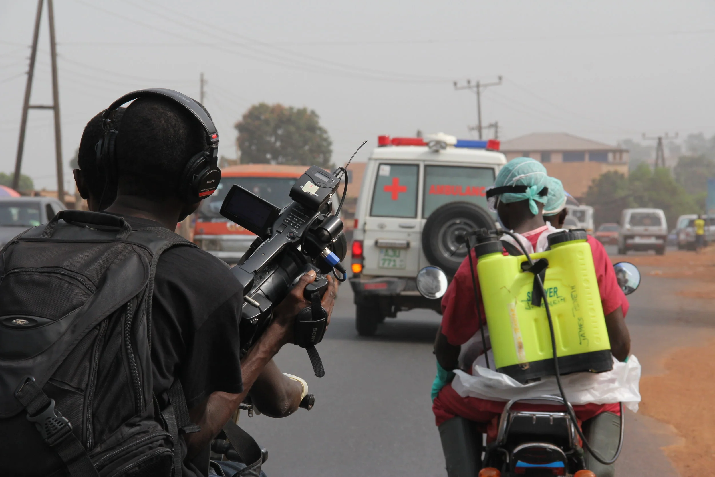 'Survivors' co-director Arthur Pratt holding camera on the back of an Okada.