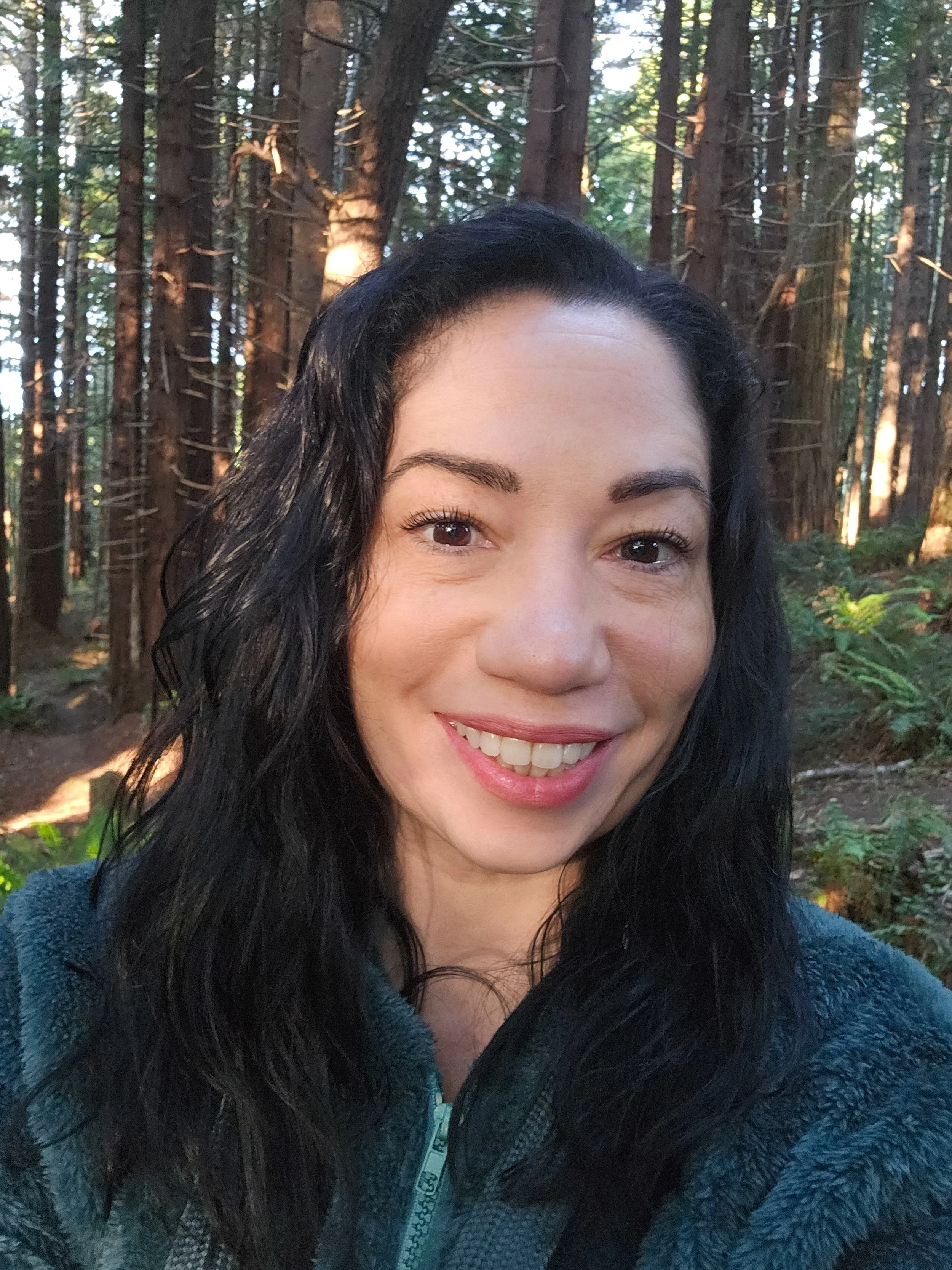 April, founder of Veiled In Bloom, in the Redwoods during breathwork facilitator certification training.