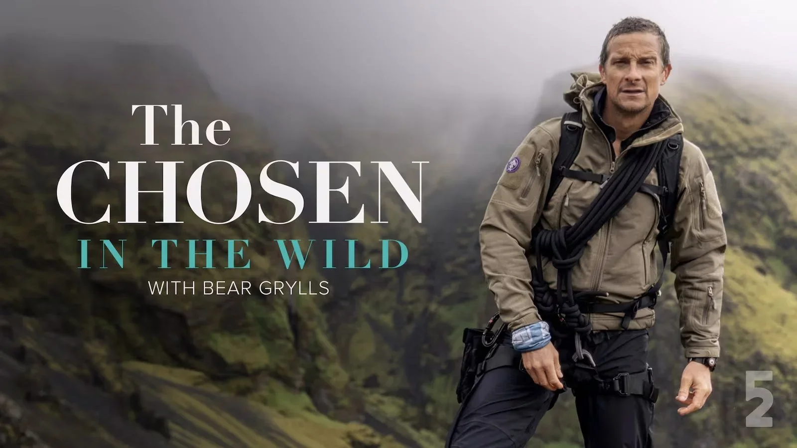 Bear Grylls dressed in outdoor hiking gear, standing in a foggy wilderness landscape with green moss-covered cliffs behind him, promoting a show titled 'The Chosen in the Wild with Bear Grylls.'